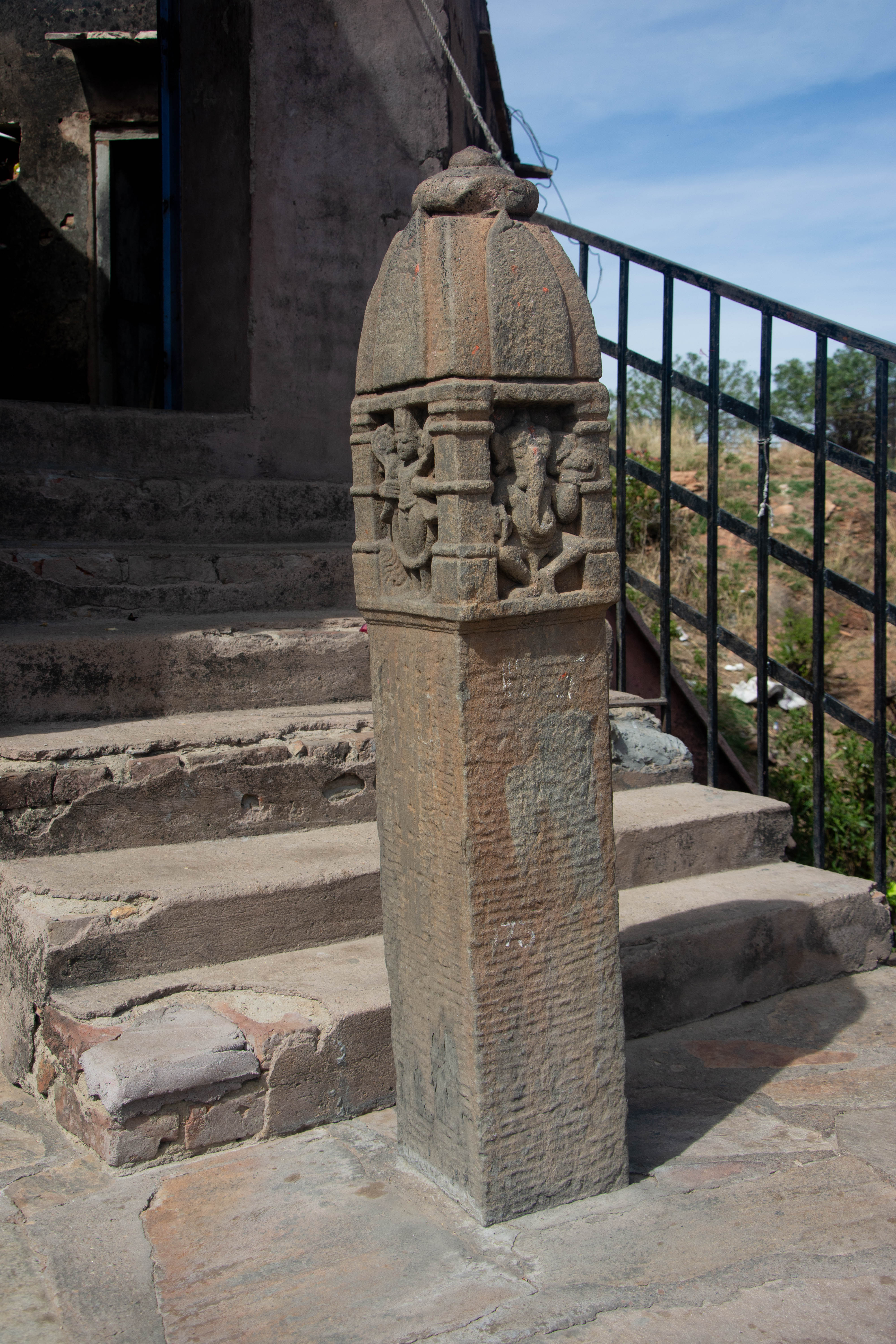 These pillars, popularly called Govardhan pillars, are quite common in several regions of Rajasthan, particularly the more arid regions of Thar and Maru. In certain instances, the image of Govardhan-Krishna may not always be present. The top of the pillar is shaped like a temple, and the niches on three sides have images of Ganesha, Vishnu, and Shiva, while what appears to be the principal face has two niches.