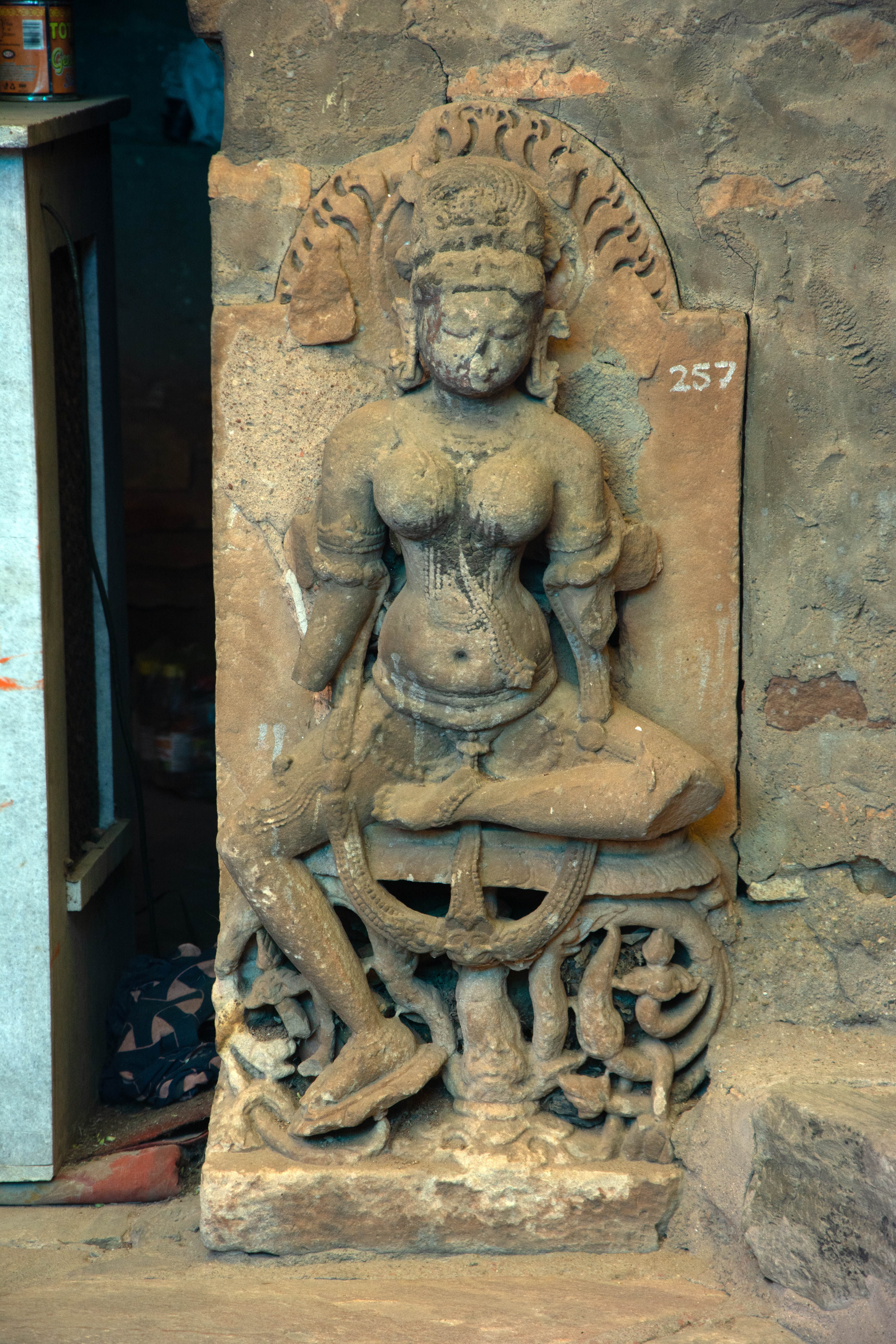 This is one of the many images of yoginis found at the site, hinting at a lost yogini temple compound. The placid expressions of this two-armed yogini, seated in the lalitasana posture, suggest her benevolent nature. Contextualizing this image with several other relevant images suggests a mature Shakti and tantric tradition at the site.