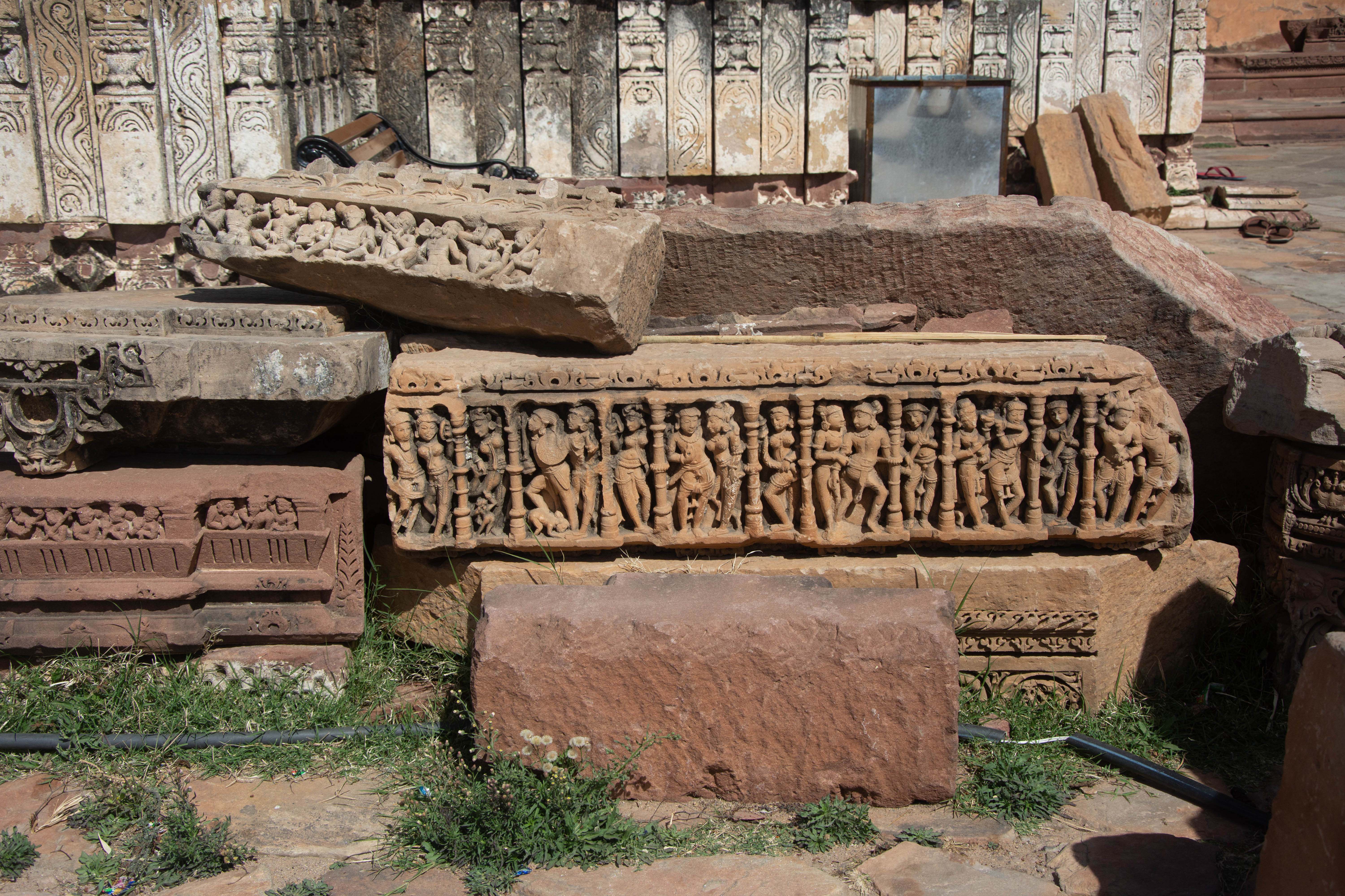 The beam, richly carved with human figures, likely sat on the temple's varandika, the adjacent areas between the temple walls and the spire. Male figures frequently carry weapons and accompany their female companions. This is one of Harsha Hill's loose architectural fragments.