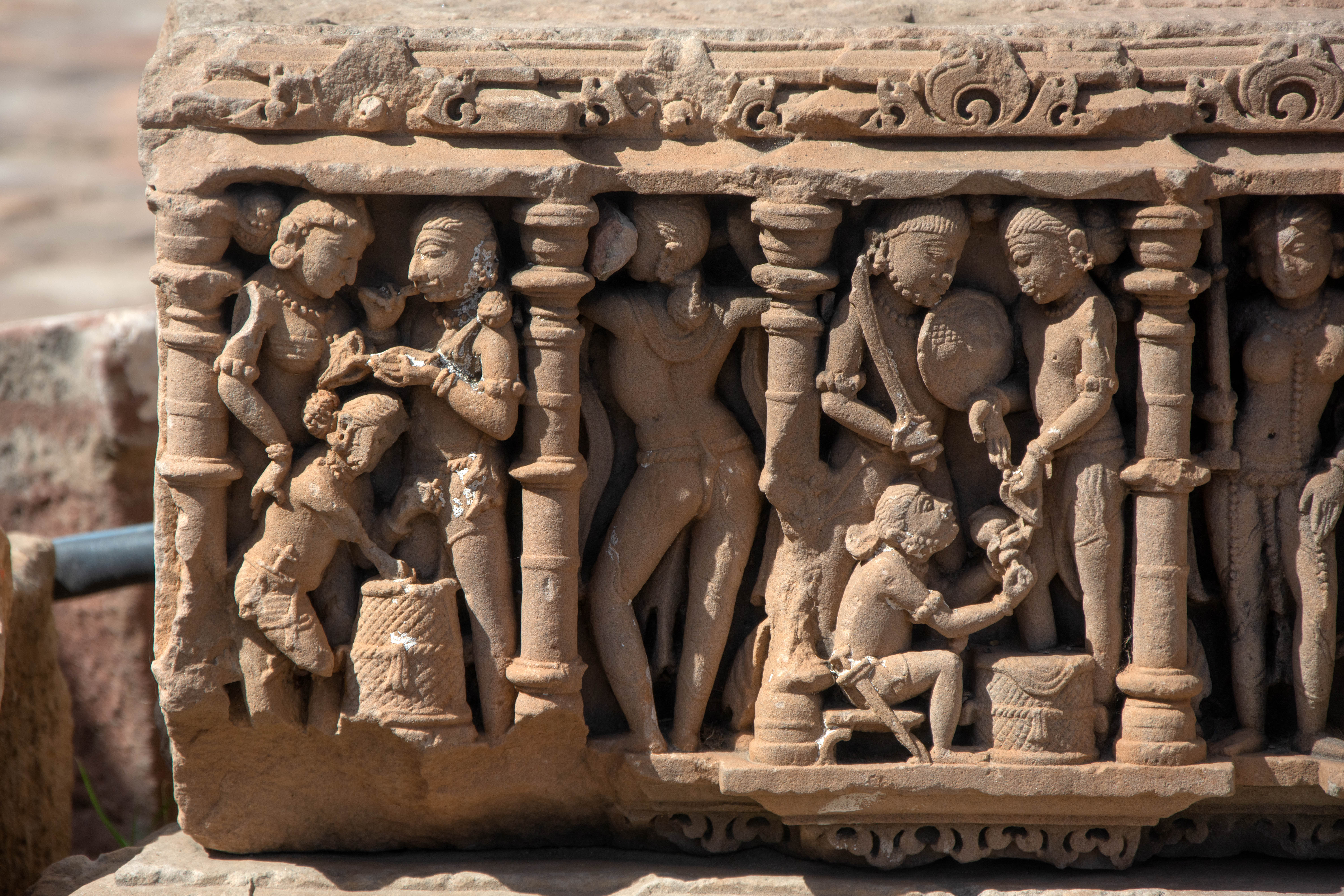 The intricately carved human figures adorning the beam likely rest on the varandika of the temple, which is the area between the temple walls and the spire. The male figures are usually shown with weapons and accompanied by female companions. This is one of Harsha Hill's loose architectural fragments.