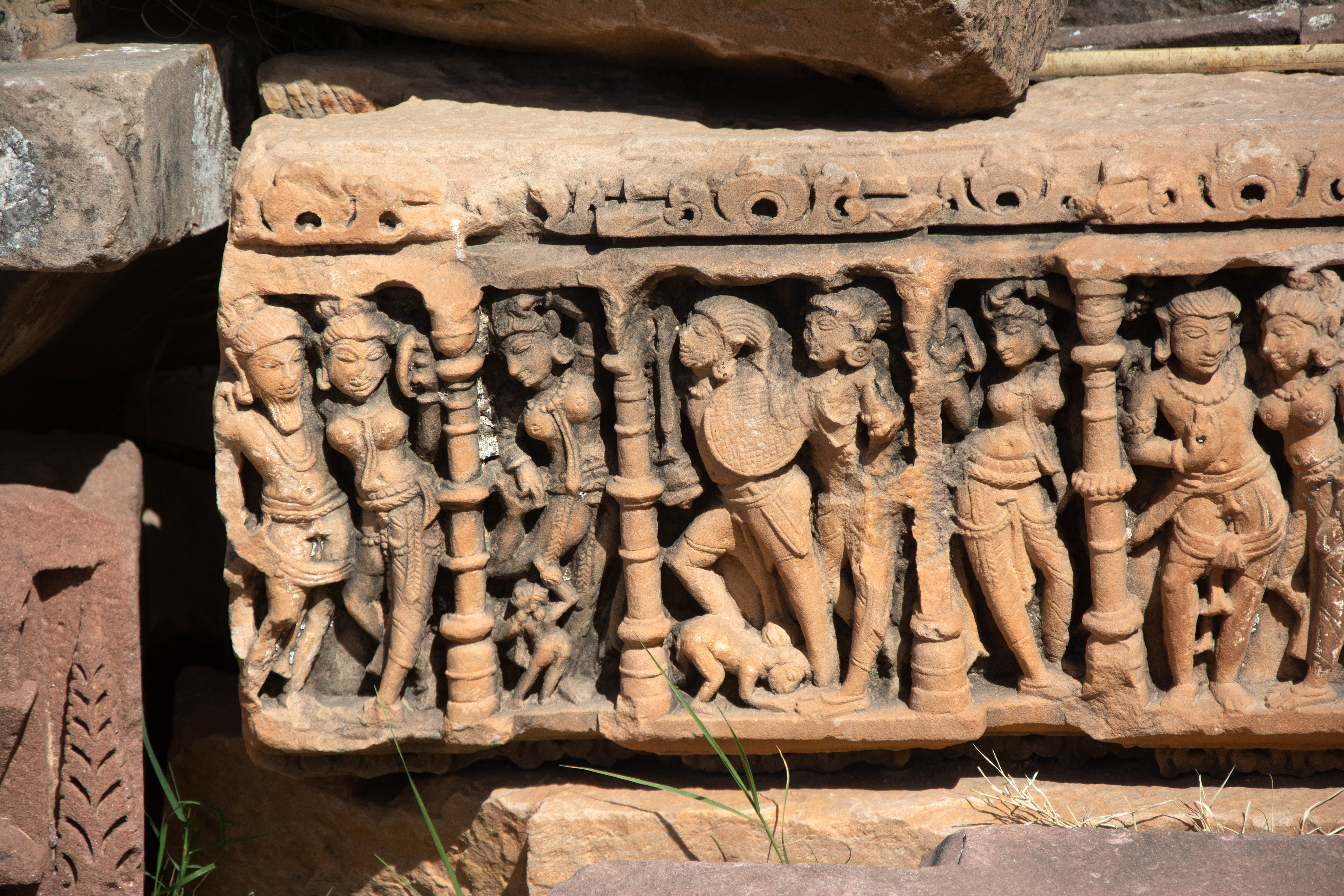 Typically, the protruding offsets house mithuna figures inside the niches, while the recess between the two offsets showcases beautifully carved images of apsaras or women engaged in various actions. Usually, female companions accompany the male figures with weapons.