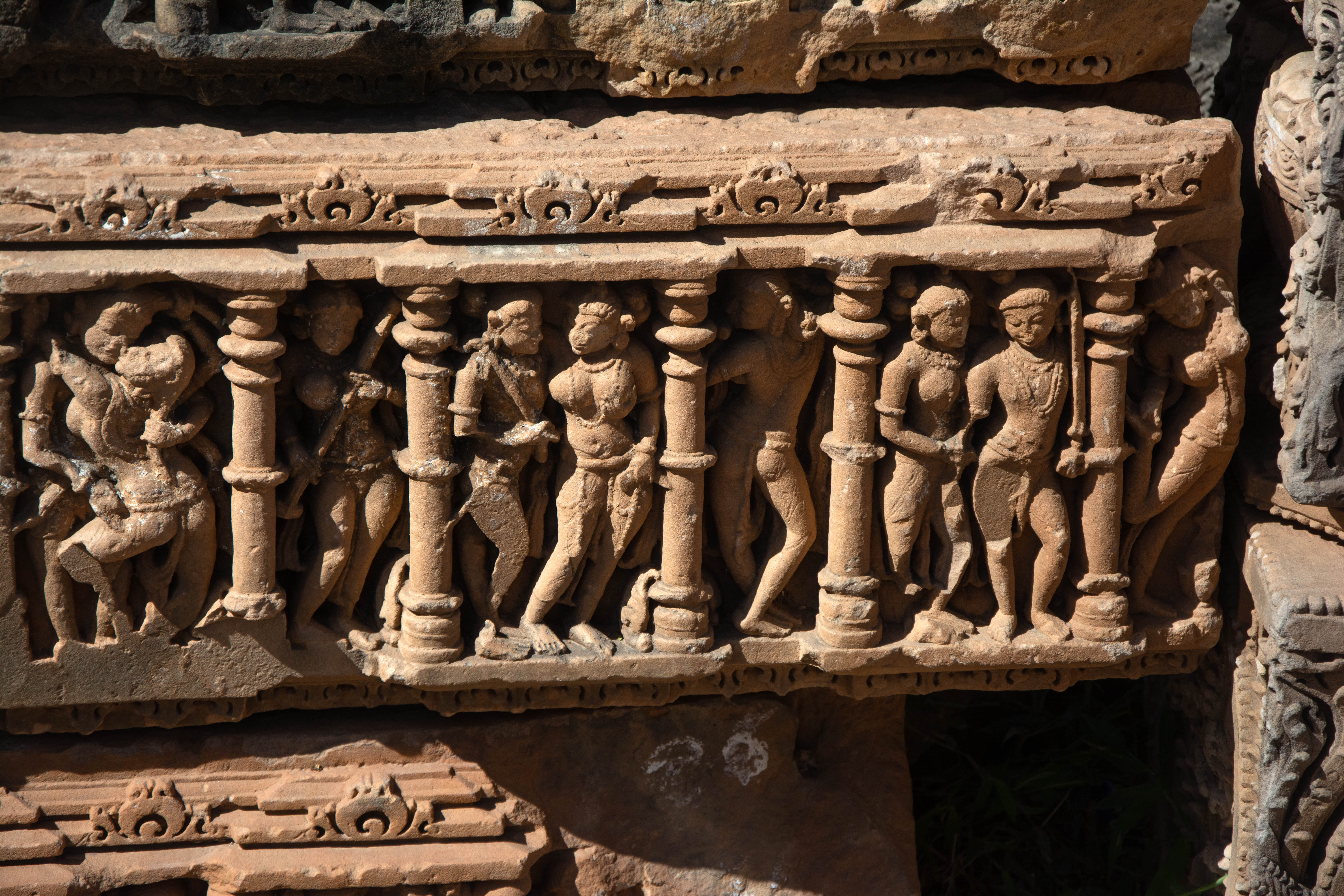 Typically, the protruding offsets house mithuna figures inside the niches, while the recess between the two offsets showcases beautifully carved images of apsaras or women engaged in various actions. Usually, female companions accompany the male figures with weapons.