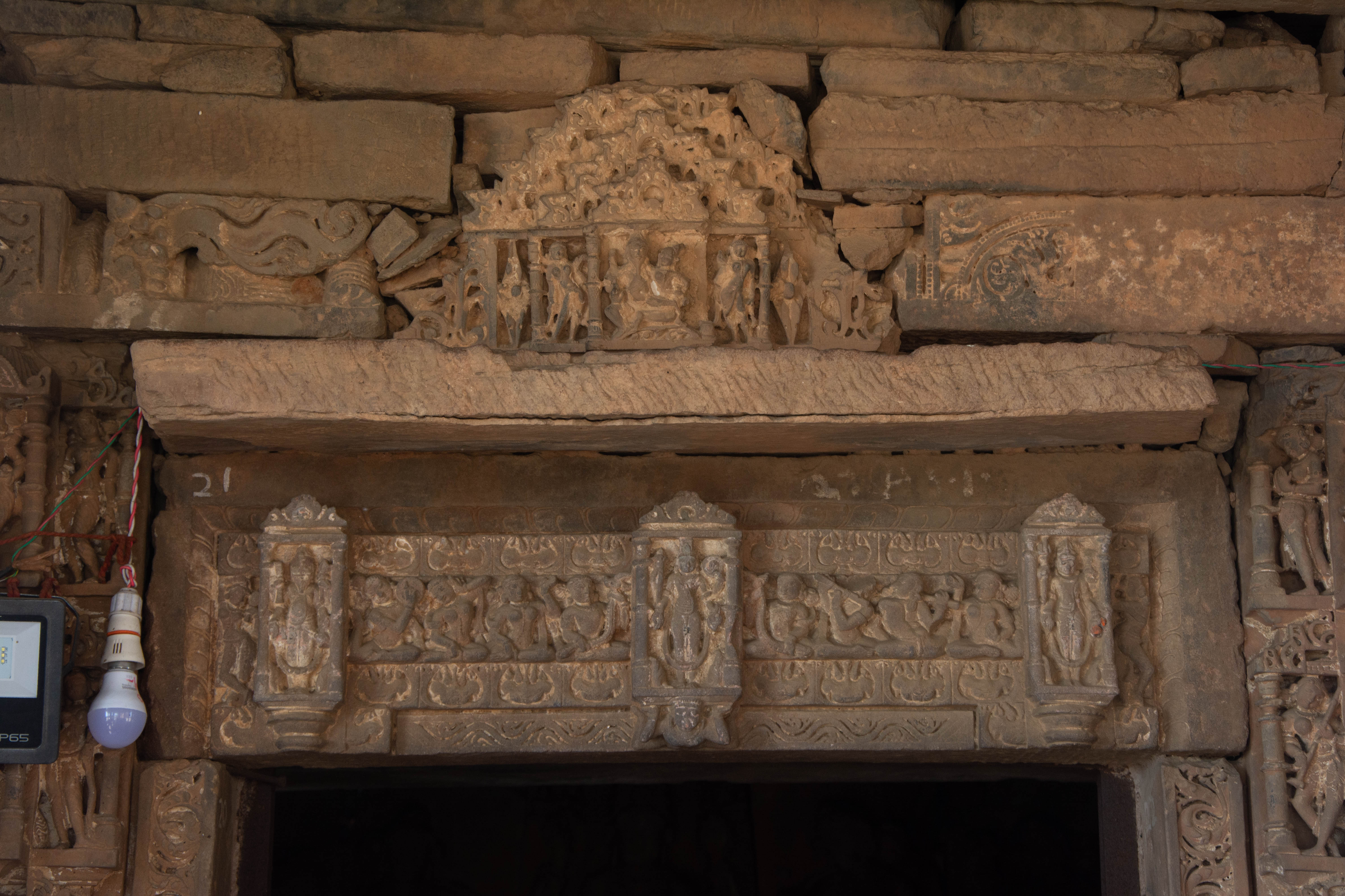 The lintel over the door jambs of the sanctum of the Harshnath Temple depicts the trio of Brahma, Vishnu, and Mahesha, with Vishnu occupying the central position. Art historian Ambika Dhaka believes that this lintel may have been a later replacement for the original lintel, which featured an image of Lakulisha at its center.