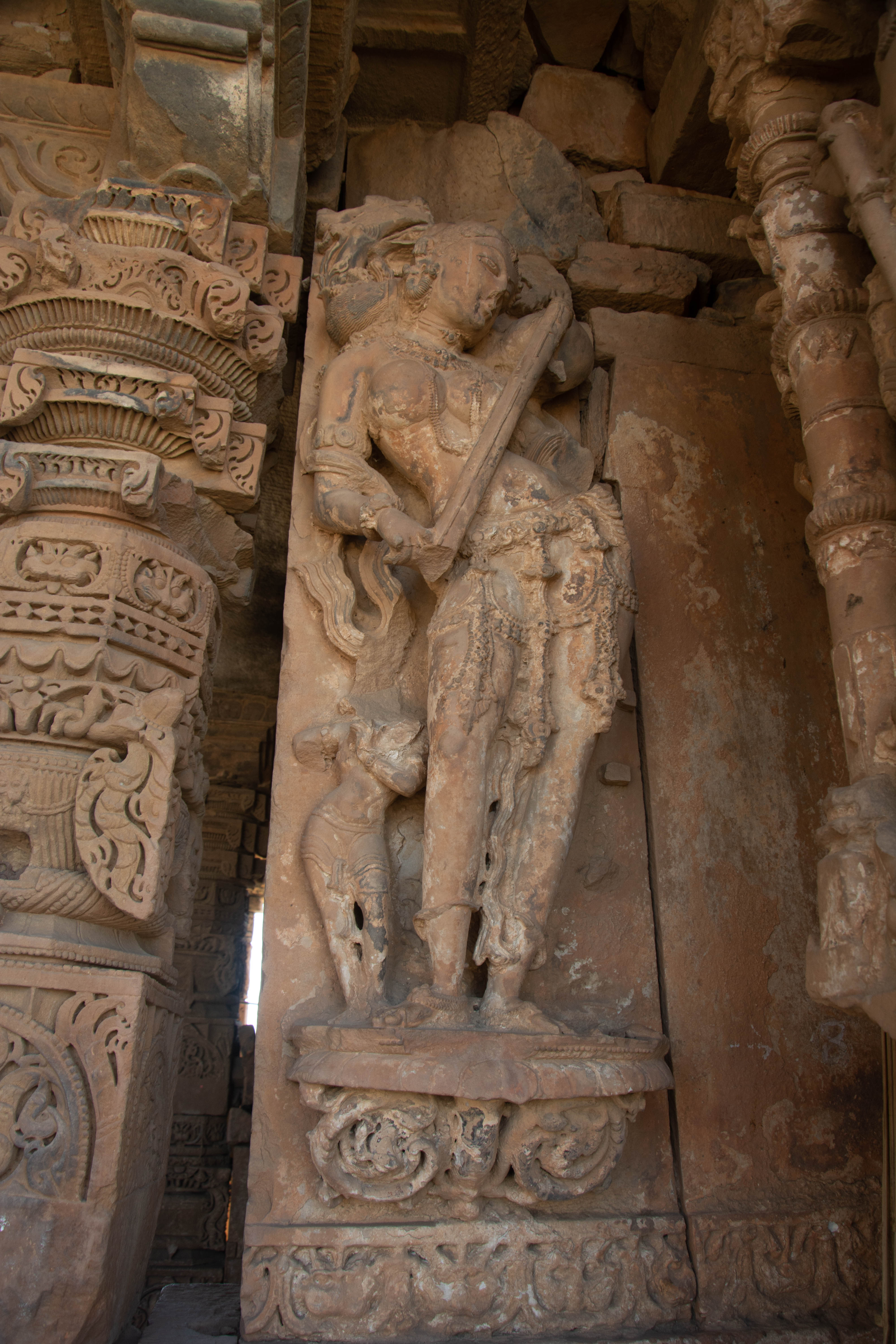 The northeastern corner of the antarala of the Harshnath Temple depicts a surasundari holding a veena.