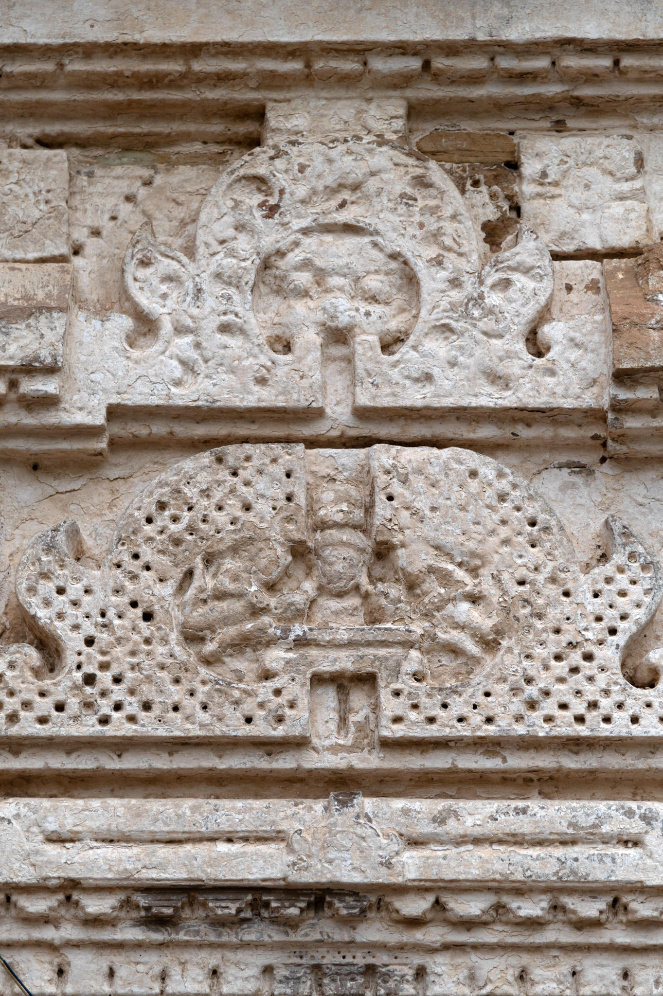 Double chaitya arches top the windows on the side walls of the garbhagriha. The lower chaitya arch depicts the bust of a deity flanked by two celestial beings. The upper chaitya arch shows a grassamukha.