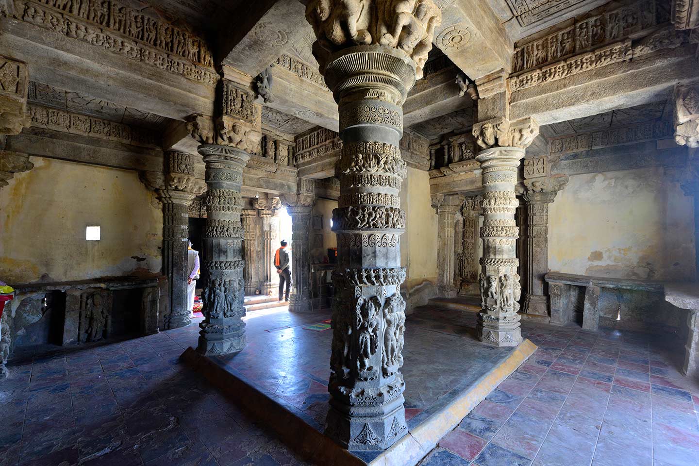 Image 4: The view of the interior of the mandapa (pillared hall) of Neelkanth Mahadev Temple as seen from the north western corner of the mandapa. In front of the three shrines of this temple is a shared mandapa with four pillars at the centre.