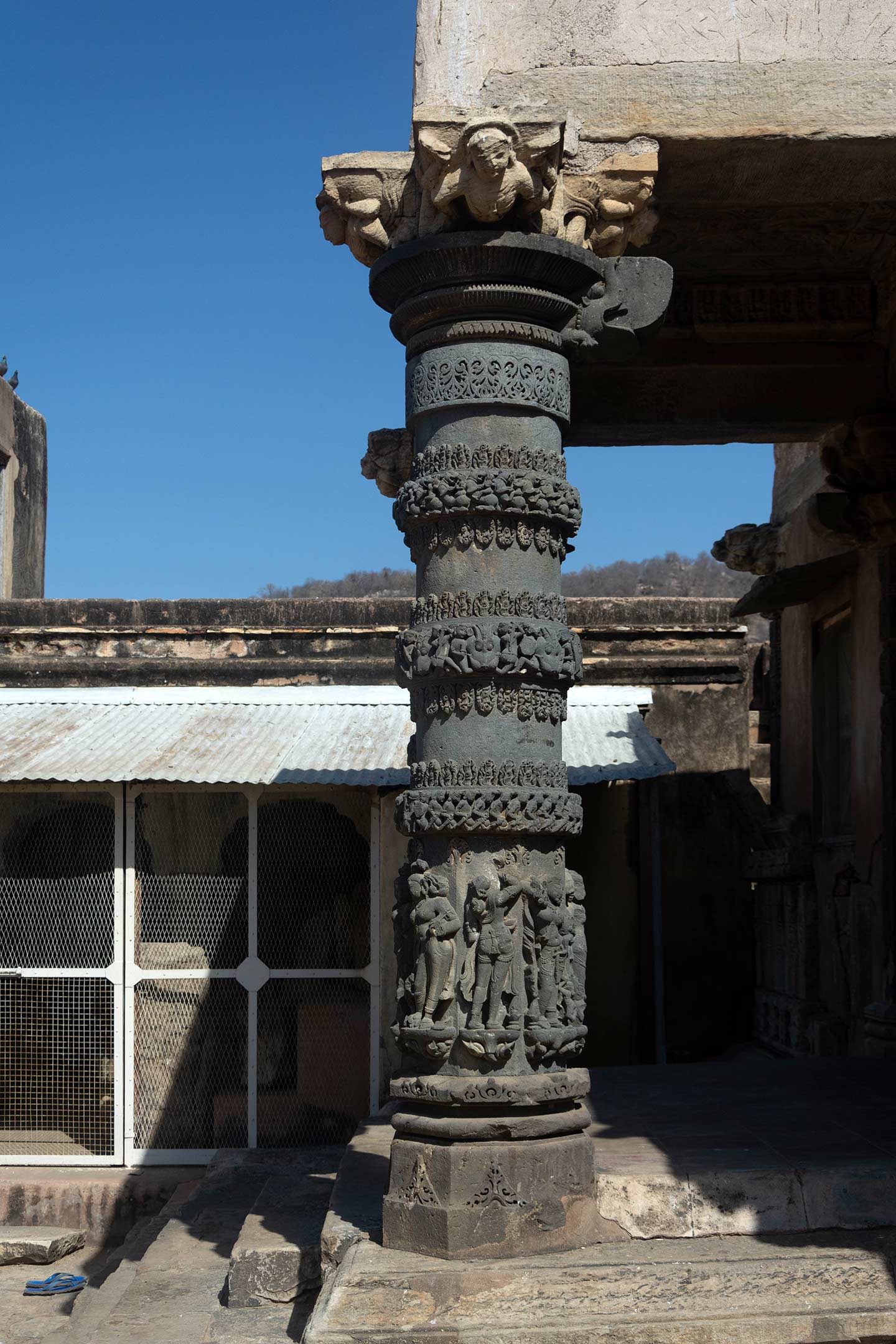 The west-facing entrance of the temple has a mukhamandapa (front porch) with ornate pillars. The pillars, octagonal in section, feature circular rings of intricate designs on their shafts, while sculptures adorn the base. A different stone than the main temple forms the pillars.