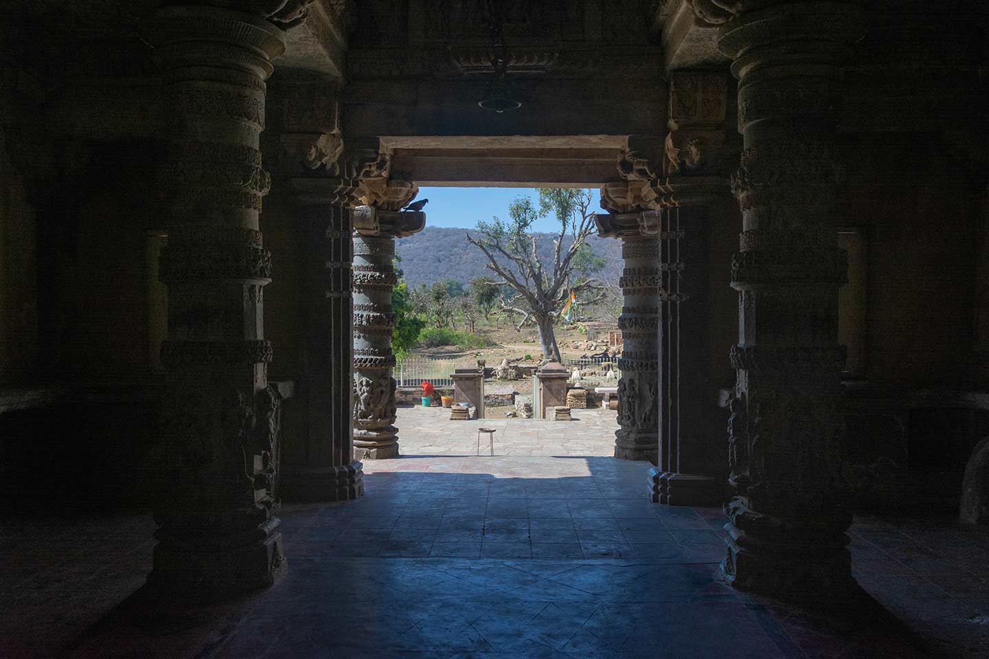 This is a view of the entrance of the Neelkanth Mahadev Temple as seen from the interior of the temple. The west-facing entrance guides visitors into a mandapa, a pillared hall that connects to three shrines.