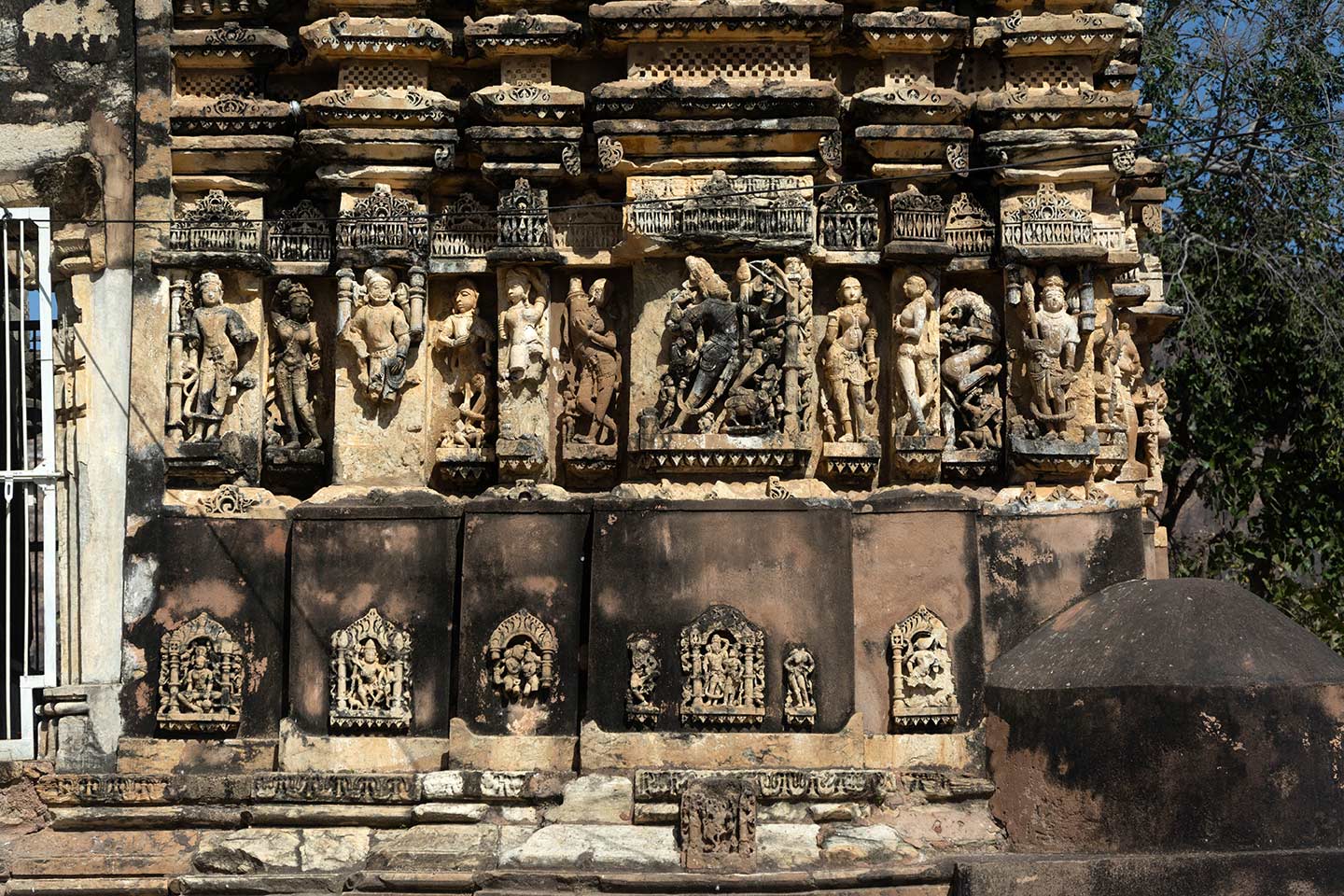 The Neelkanth Mahadev Temple's central shrine features a south-facing jangha (wall). Sculptures profusely adorn the jangha. The central bhadra (central projection) has a ferocious depiction of Shiva, and the intermediate and corner projections have ascetics, surasundaris (celestial damsels), and dikpalas (deities for cardinal directions). The recesses just flanking the central shrine have vyalas (composite mythical creatures).