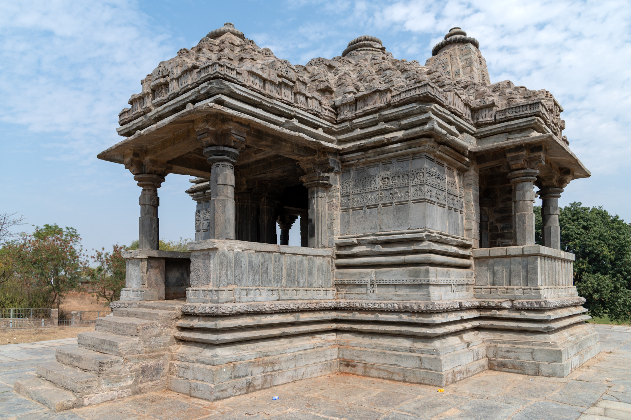 The mandapa (pillared hall) of the Shiva temple is visible from the northwestern side. There is a mukhmandapa (front porch) at the western principal entrance of the temple, which further connects to the mandapa. The mandapa is of a semi-open type, wherein the corner walls have peepal leaf motifs as surface decorations.