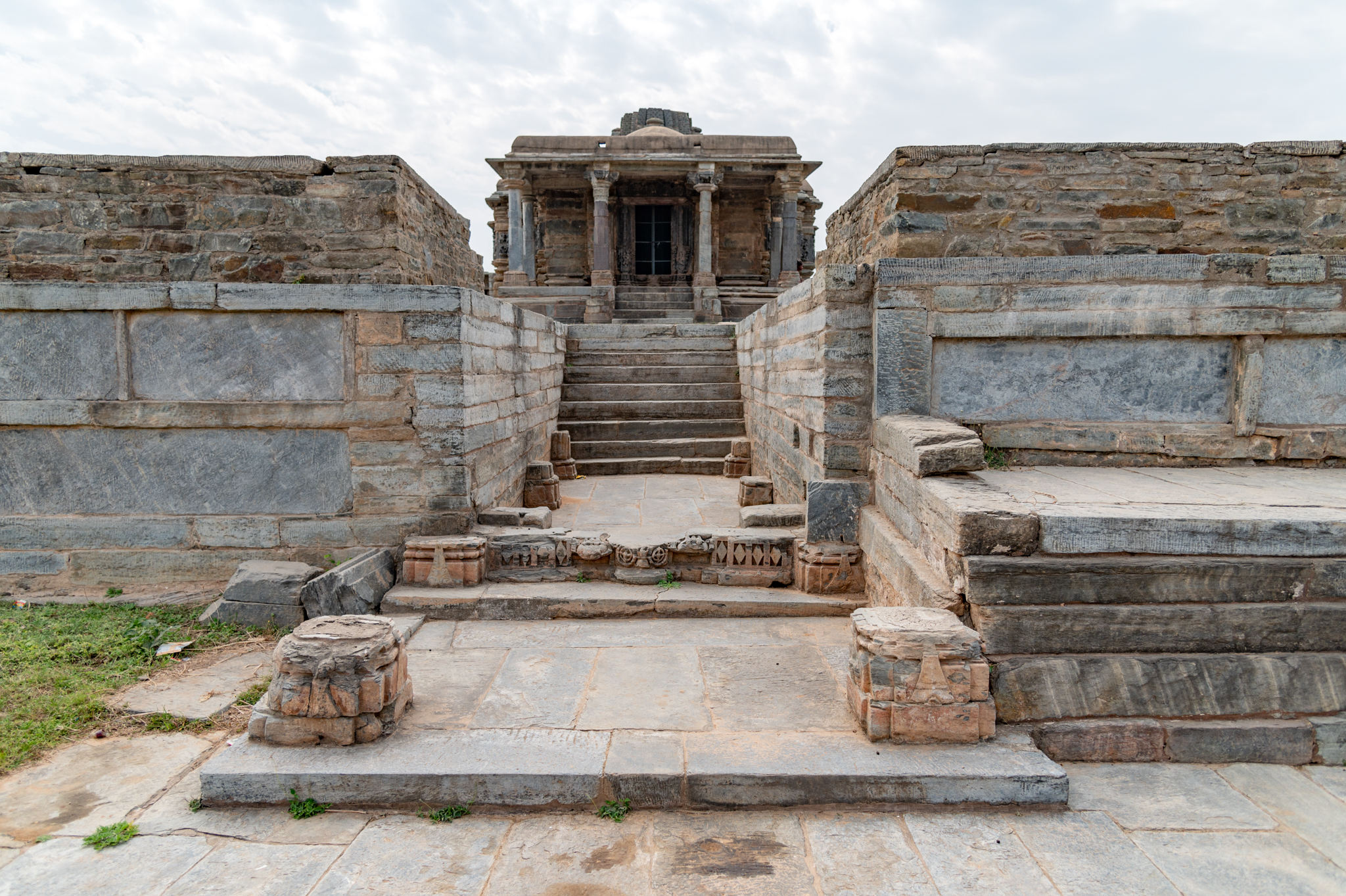 Seen here is the north-facing principal entrance of the Jain temple complex. A flight of steps leads to the temple's elevated platform. The entrance is marked by pillar remains on four corners, which must have supported a semi-opena pavilion connected to the temple complex's raised platform.