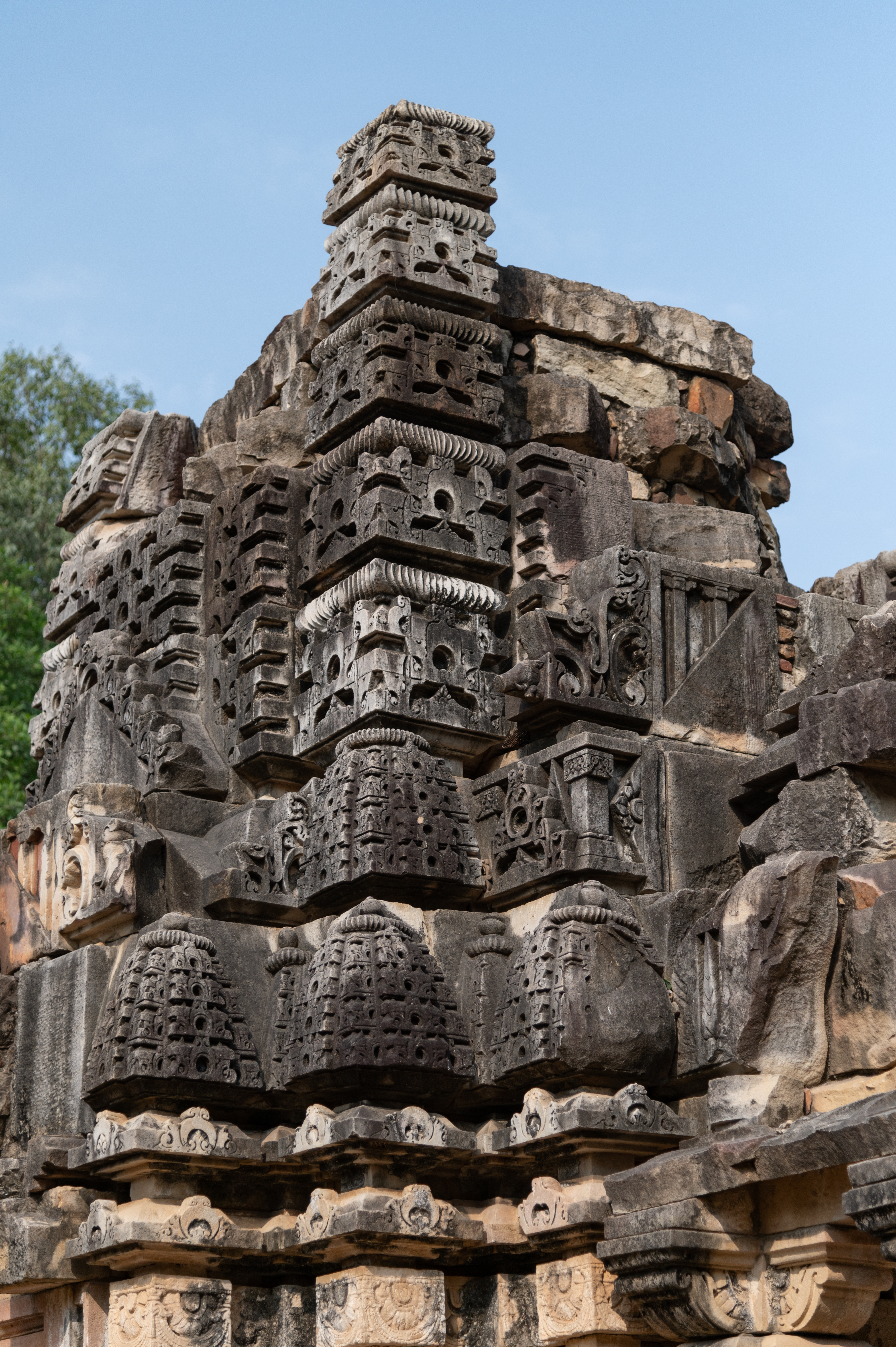 The shikhara (superstructure) of the garbhagriha (sanctum sanctorum) of the Shiva Temple (Temple 3) is severely damaged, but remains of the mulamajari (central or main spire) can still be seen, carved with the jala of miniature gavaksha (dormer window) motif. The karnaratha (decorative pilasters) of the present superstructure shows five bhumis (tiers), and the arrangement of the anga shikhara (minor spires) can be seen just above the varandikas (moulded parapet).