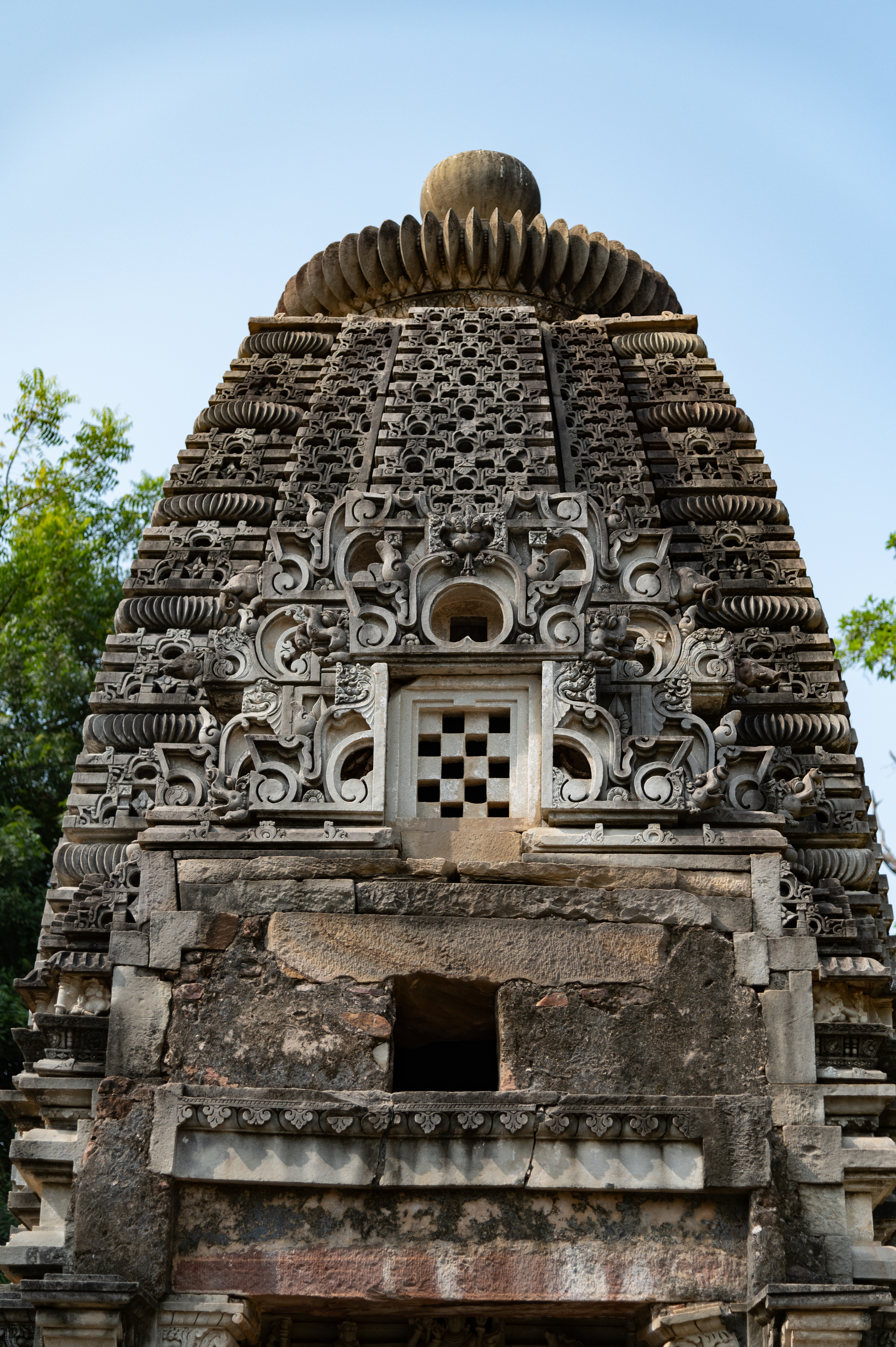 The shikhara (superstructure) exhibits an integrated jala of chaitya arches but the beauty of the shikhara lies on its frontal face which depicts an arrangement of gavaksha (dormer window) arches topped by a kirtimukha (face of glory), along with a portrayal of elegantly carved makaras (crocodiles) and majestic faces of elephants on the sides. Additionally, floral motifs and shankhas (conch shells) are also used to decorate the frontal façade of the shikhara.