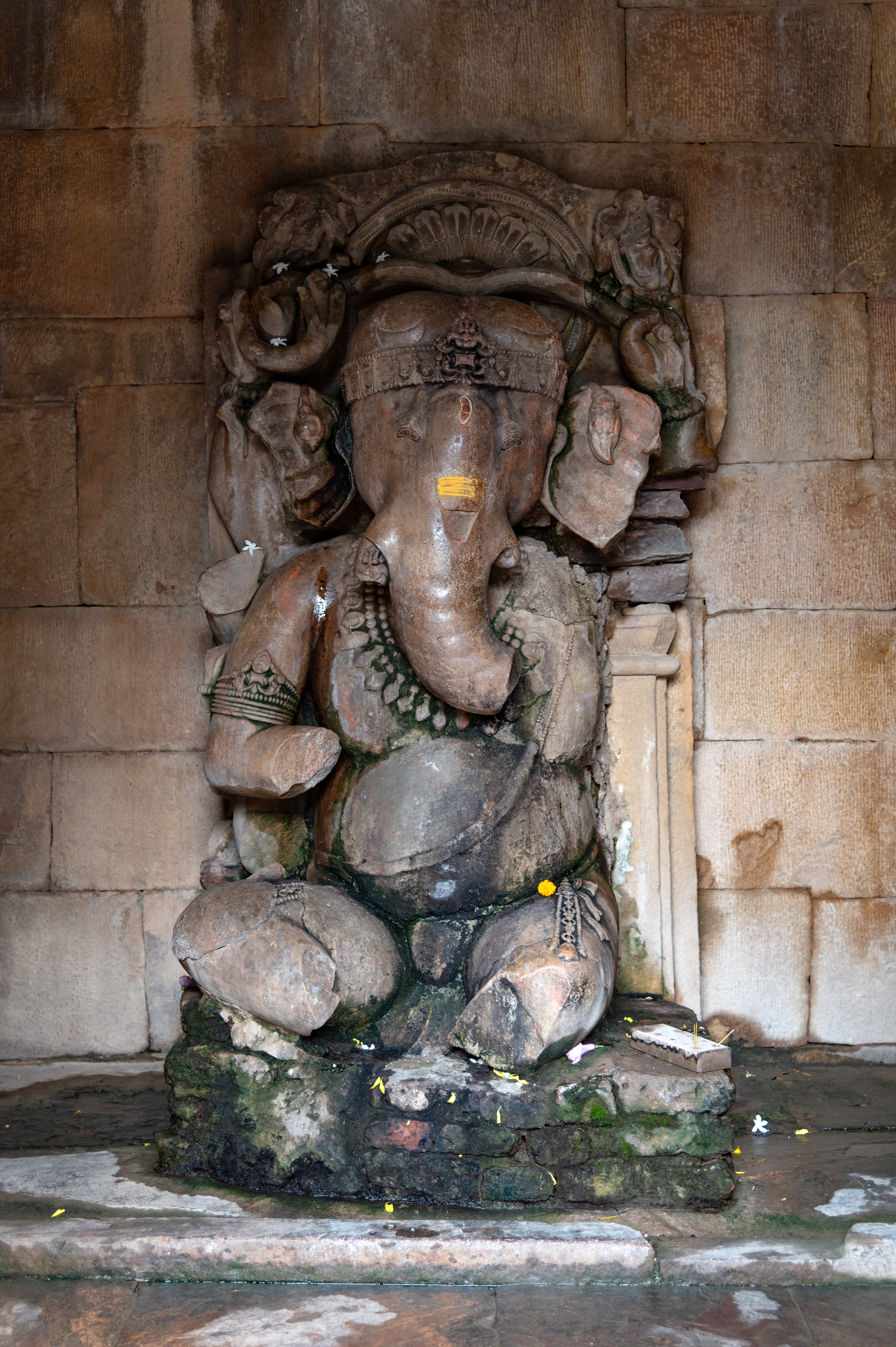 The garbhagriha (sanctum sanctorum) of the temple houses a sculpture of Ganesha. He is shown dancing gracefully. Although he originally had multiple arms, only the upper two remain intact, holding a snake. A halo in the form of a full-blown flower surrounds his form.