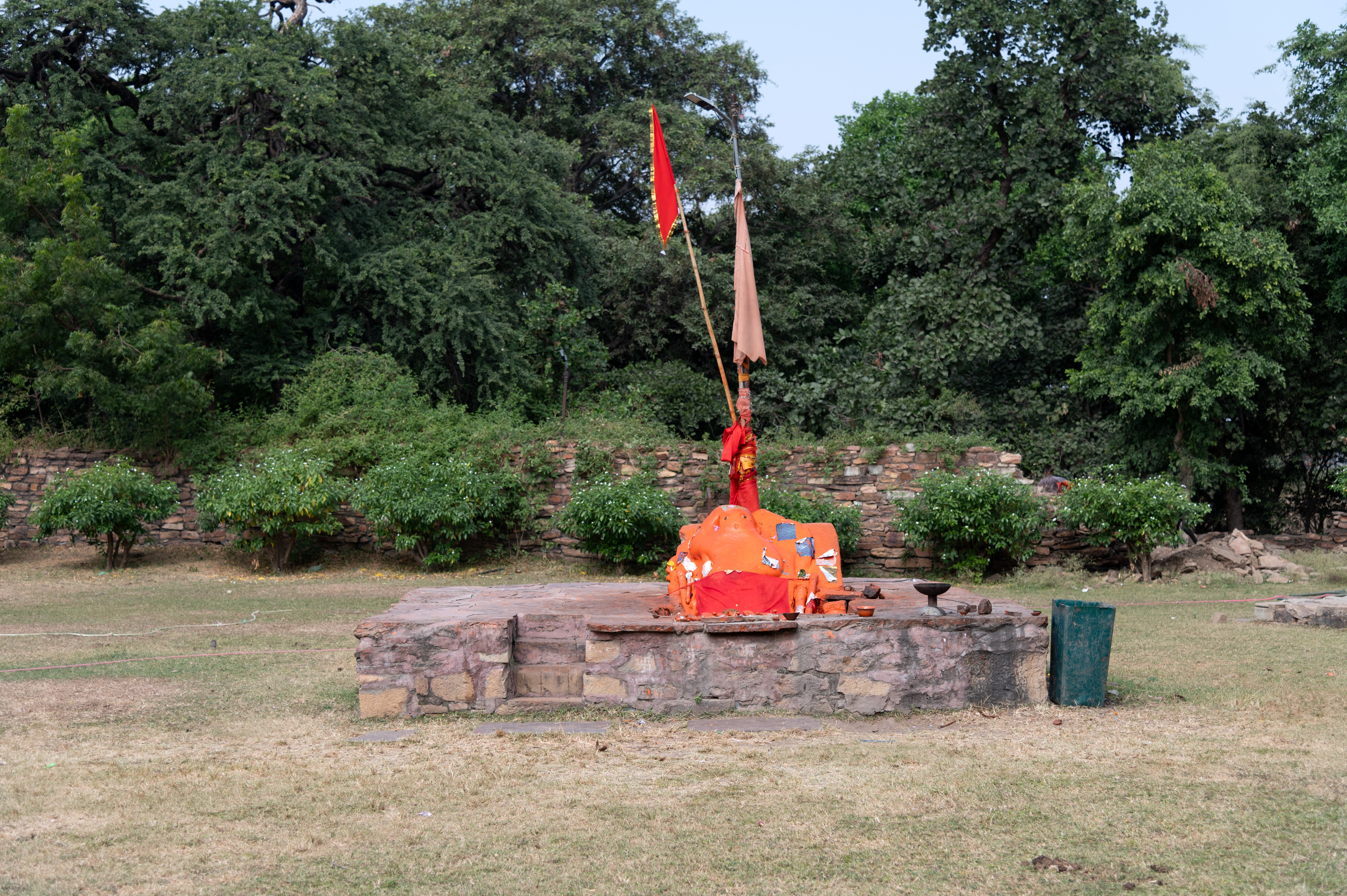 There is a platform on which a sculpture of an unidentified deity is placed. According to the locals, the deity covered in vermilion is Hanumana.