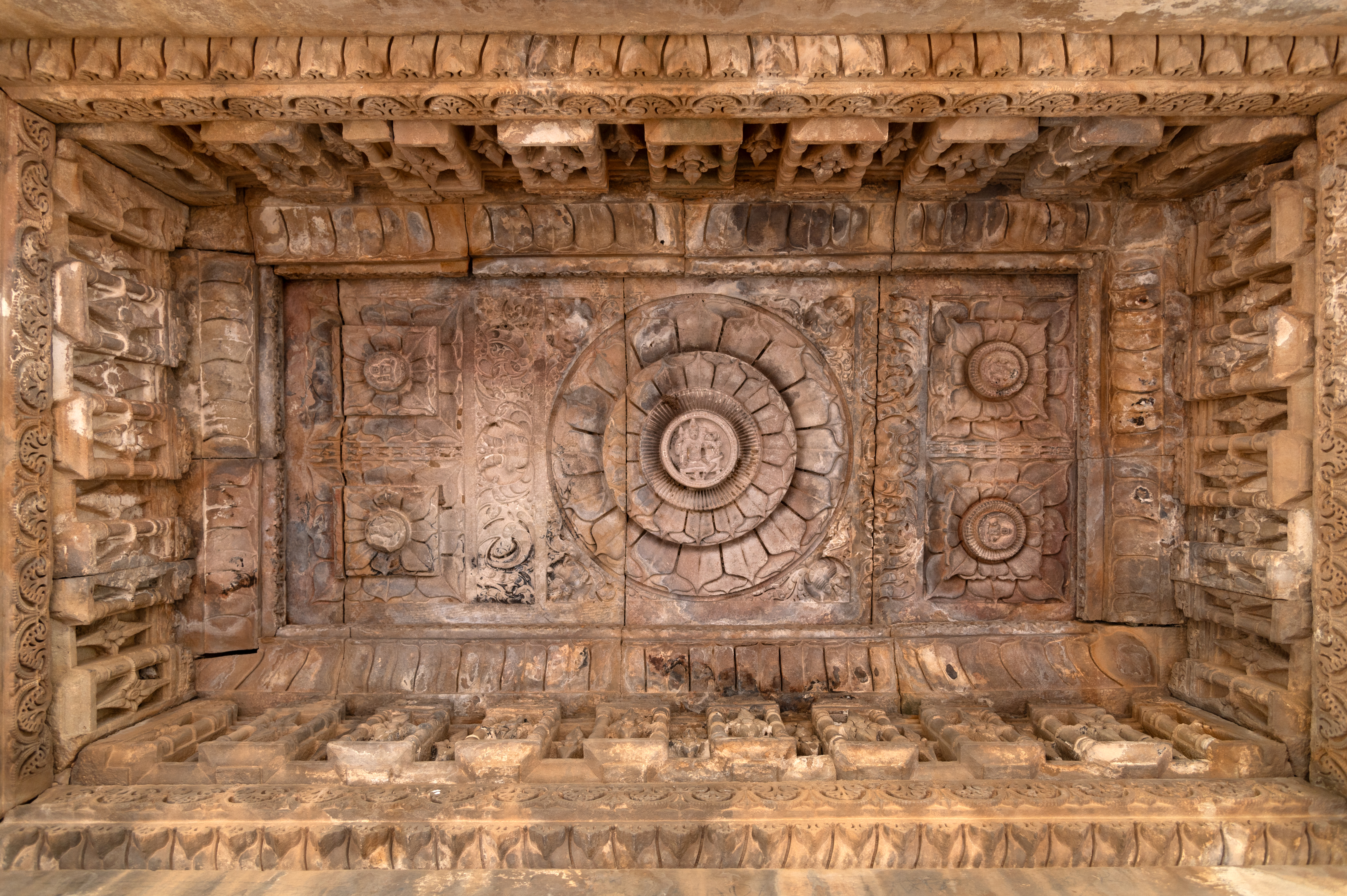 The ceilings of the rangamandapa (open type of pillared hall) are intricately carved, presenting a variety of ceiling types and motifs. One of the rectangular ceilings depicts a full-blown lotus, with the figure of a divine couple at the centre. The male deity is shown seated, holding his attributes and embracing his consort, who is shown seated in his lap. The central flower is surrounded by four small flowers, each also depicting a divine figure at the centre.