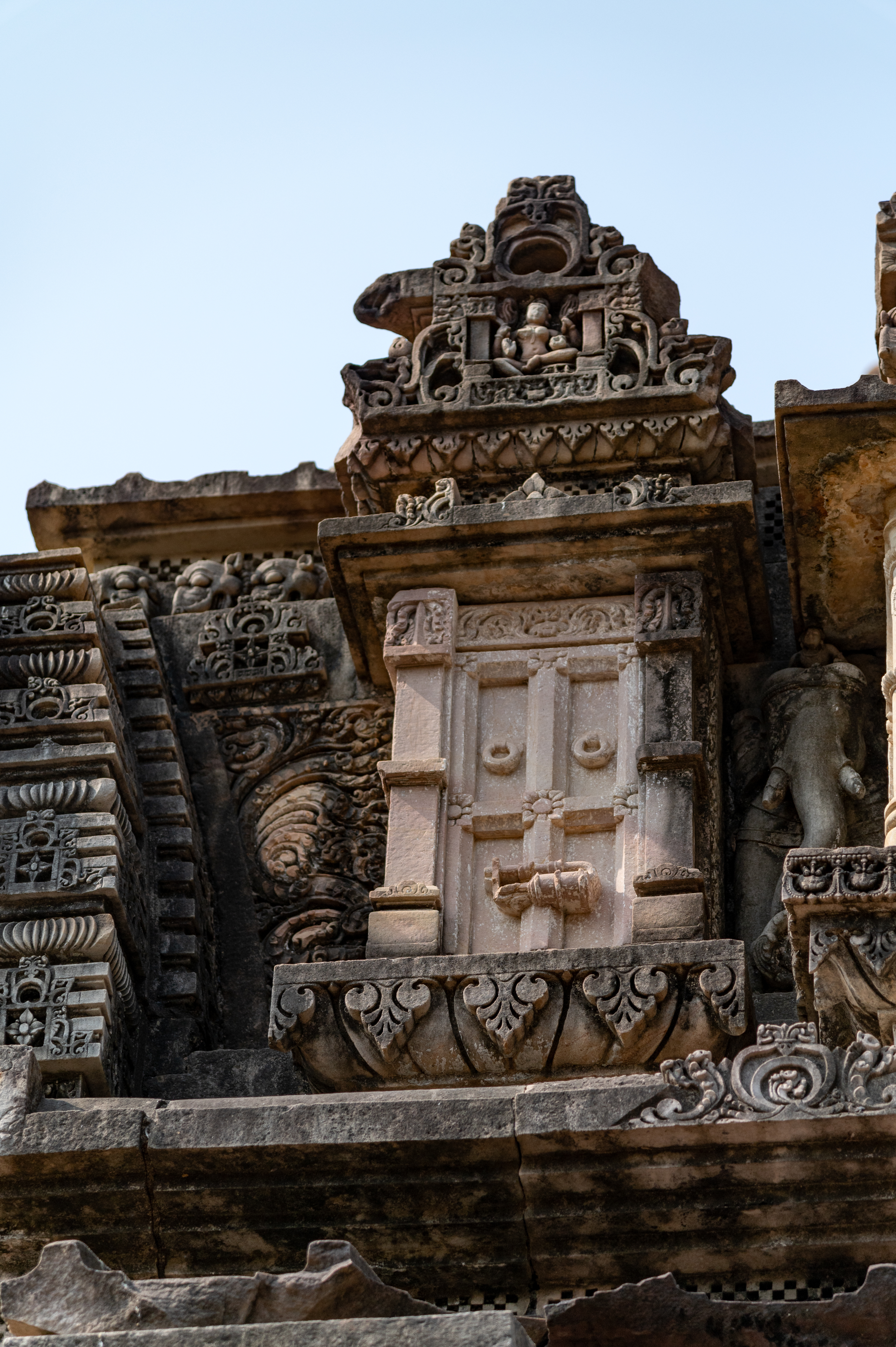 The frontal pediment of the shikhara (superstructure) of the mukhamandapa (front porch) depicts locked doors, which is the most distinct element of the pediment, used here as a decorative motif. These closed doors represent the types of wooden doors prevalent in the region during this period. The depiction is noteworthy as it also depicts a variety of heavy locks which were used in the old havelis of Rajasthan. Such representation of doors and locking systems is rarely found in temples, making the presence of these elements as decorative motifs in this temple particularly unique.