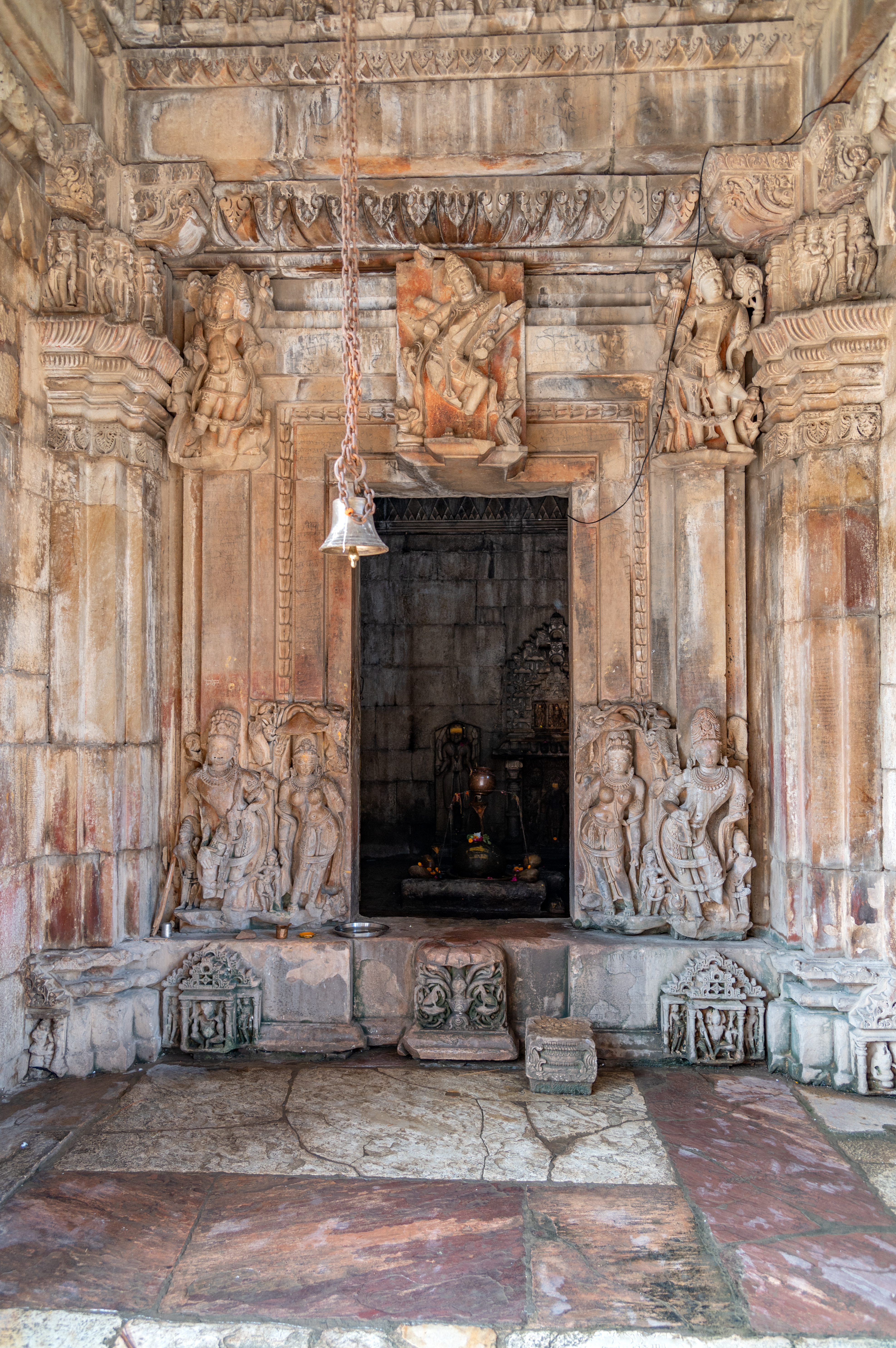 The garbhagriha (sanctum sanctorum) can be accessed through a doorframe which is carved with the figures of river Goddess and dvaralapalas (door guardians) at the bottom and the trinity—Shiva, Vishnu and Brahma on the lintel. The dvarashakas (architraves or doorjambs) are plain except for one, which shows a floral design.