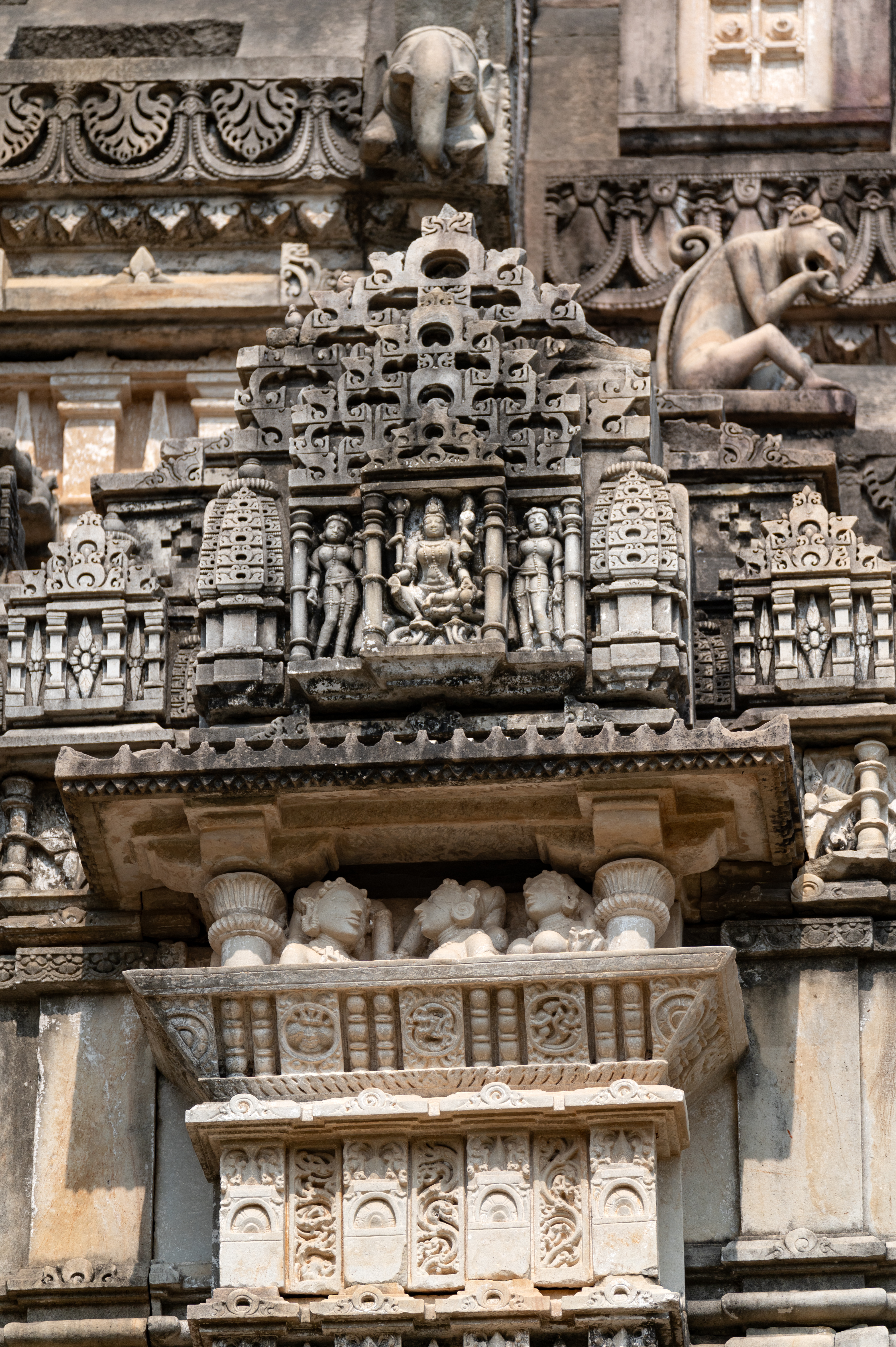 The southern side of the sukanasa (antefix above the roof of the kapila) is carved with a distinct scene depicting a miniature balcony where three beautiful women are shown conversing with each other. Above the balcony, an udgama (pediment of interconnected chaitya dormers) is placed, depicting a four-armed goddess seated on a lotus seat, flanked by two attendants.