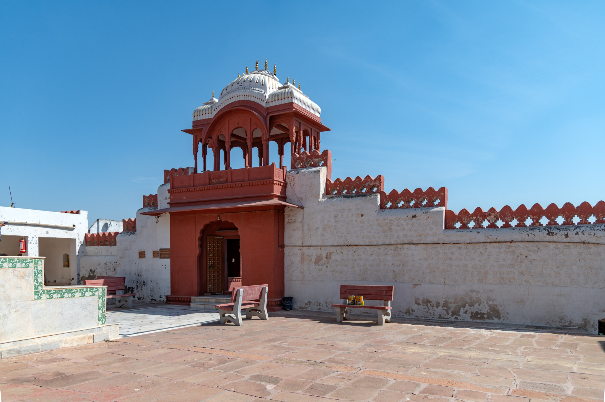 The entrance gateway of the Bhandasar Temple, on the inside, connects to the enclosure wall of the temple complex. The enclosure wall has merlons on its edge and diminishes in height from the gateway.