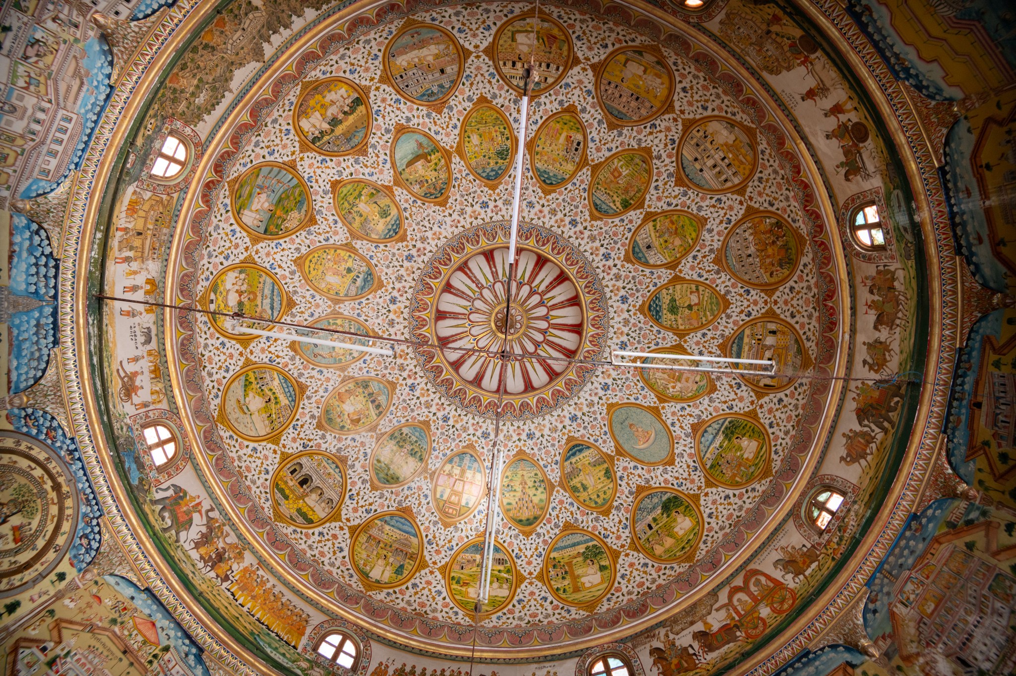 The dome above the mandapa (pillared hall) of the Bhandasar Temple has two circles consisting of sixteen oval-shaped designs fashioned like mirrors. The outer or lower row has miraculous deeds from the life of Jain Acharyas, Dada Guru Jinadatt Suri and Dada Guru Jinachandra Suri. The inner or upper row has stories from the lives of Rishabnatha, Mahavira, Parshvanatha and Neminath Tirthankaras.