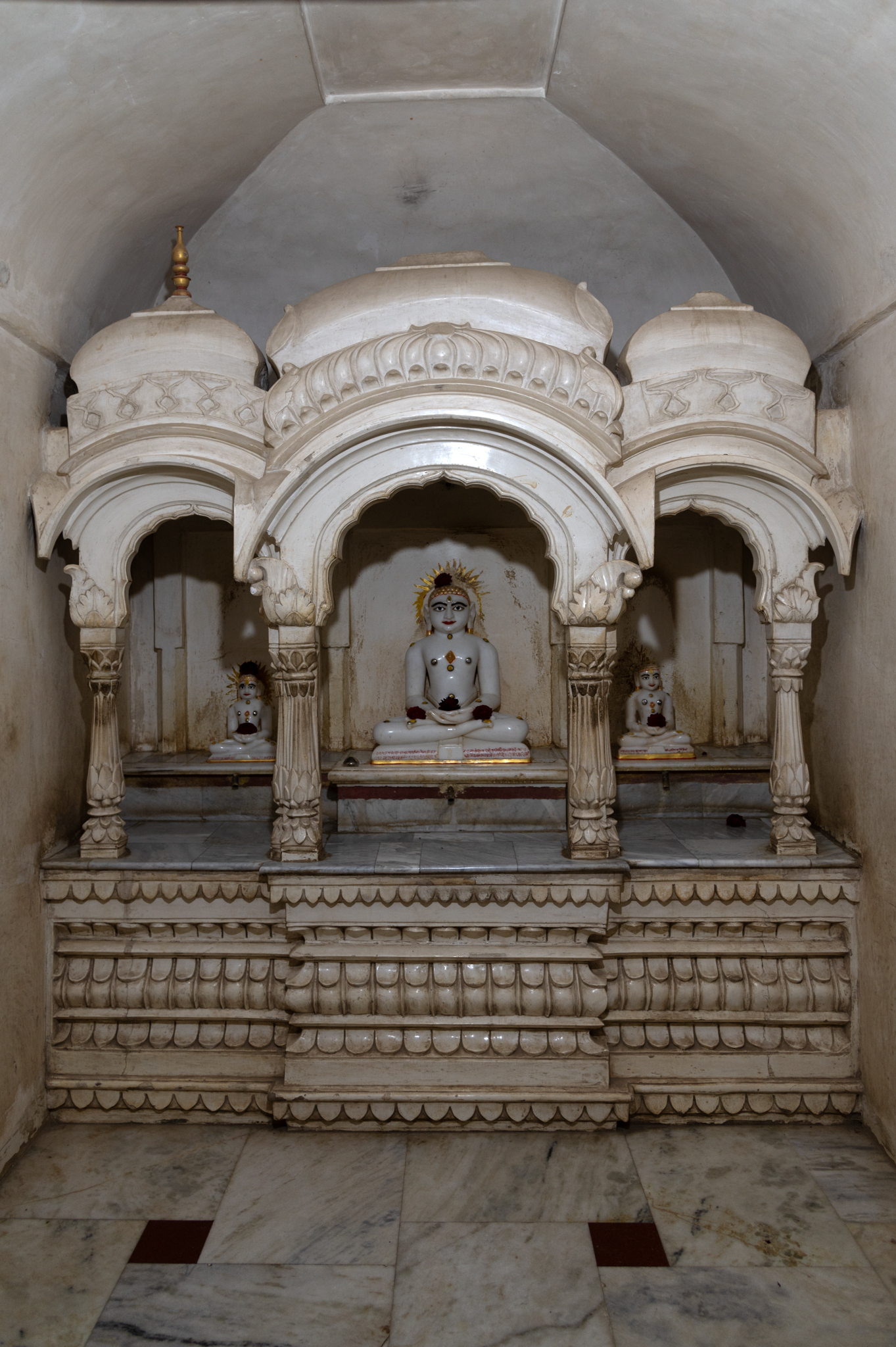 Within the Adinatha Temple, there is a side shrine that enshrines images of Tirthankaras. This small subsidiary shrine is on the southern side of the main garbhagriha (sanctum sanctorum). A triumphal arch with three divisions, this small temple has three icons on a high pedestal, all sitting in padmasana (lotus pose).