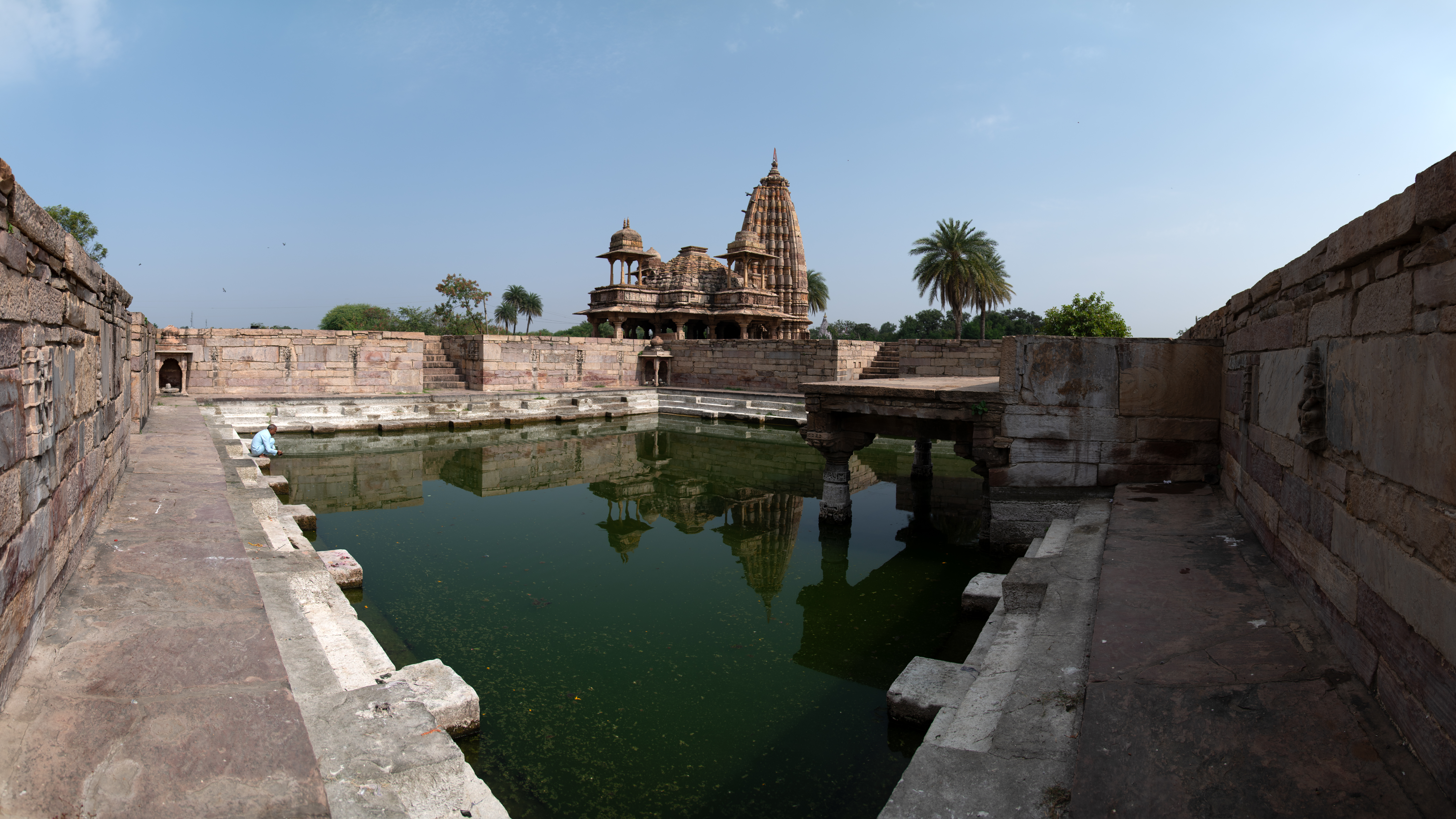 The Mandakini Kund is a square-shaped reservoir of sacred water with entrances on three sides. Flights of steps are provided on each side, facilitating access for people to descend into the holy water. On the fourth side of the reservoir, there is a visible flat-roofed structure supported by pillars. Moreover, there are two petite pavilions located at the corners of the reservoir.