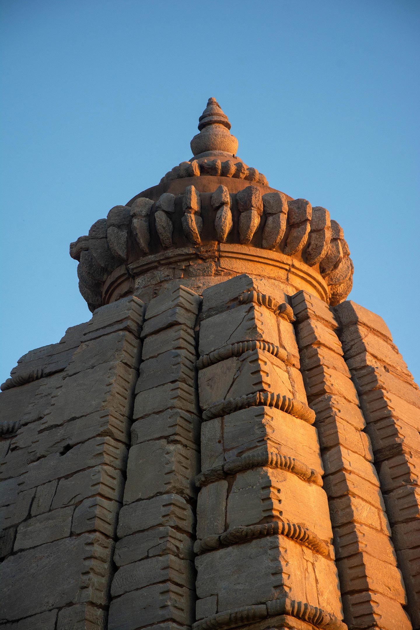 The shikhara (superstructure) is divided into nine storeys, marked by eight bhumi-amalakas (a segmented or notched stone disk, usually with ridges on the rim) positioned at each of the four corners. Above this truncated top of the shikhara, standard elements such as amalaka, kalasha (pitcher), etc., are present.