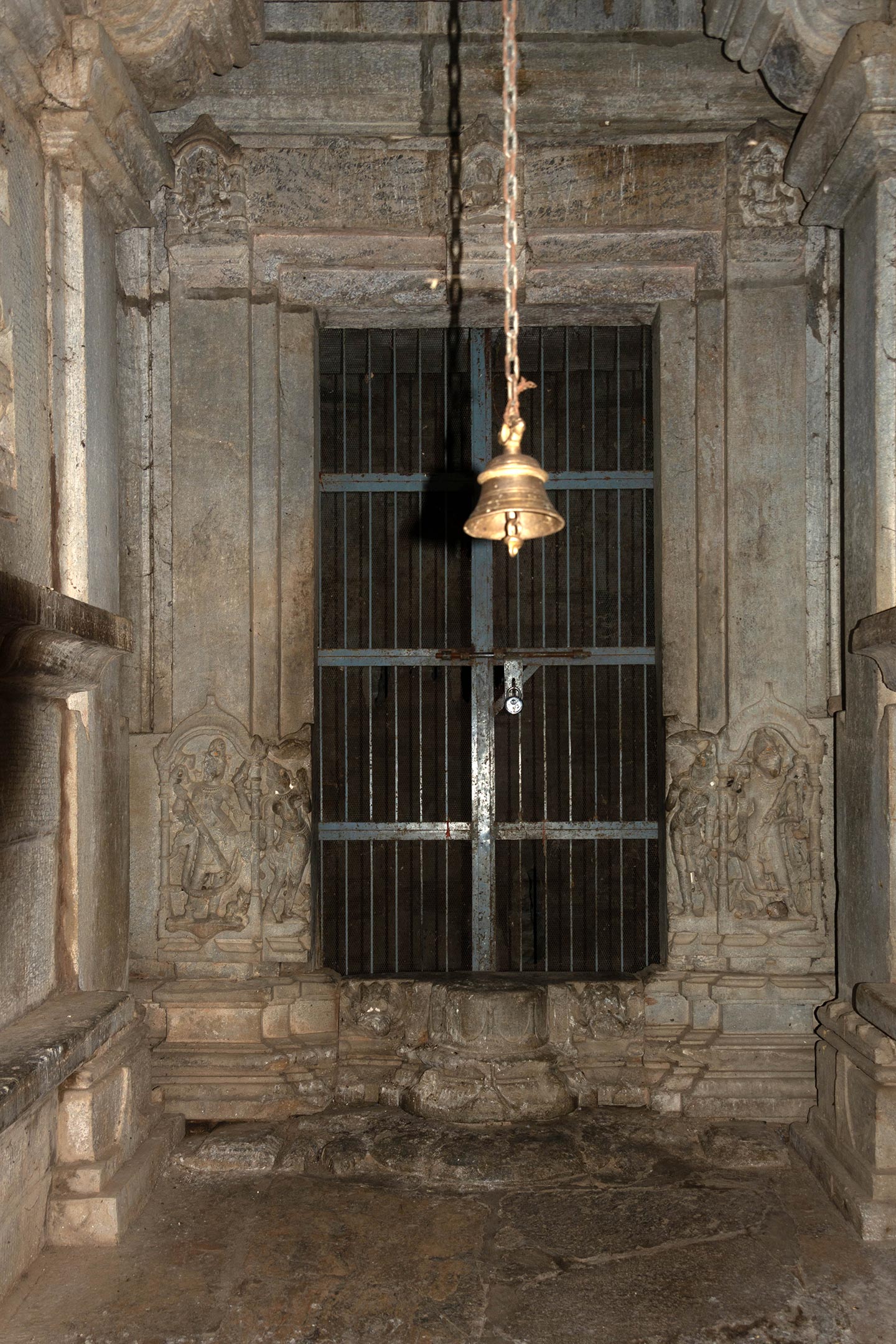 The jamb of the doorway is carved with sculptures of Ganga and Yamuna, along with a Shaiva dvarapala (door guardian). The lintel of the sanctum doorway features a two-armed depiction of Lakulisha seated in padmasana (lotus pedestal pose) in dhyana mudra (meditative hand gesture), carrying a lakuta (club) in his left hand and fruit in his right hand, inside a niche on the lalatabimba (lintel). Flanking Lakulisha, there are depictions of a four-armed Brahma and Vishnu on the right and the left hand of the lintel, respectively.