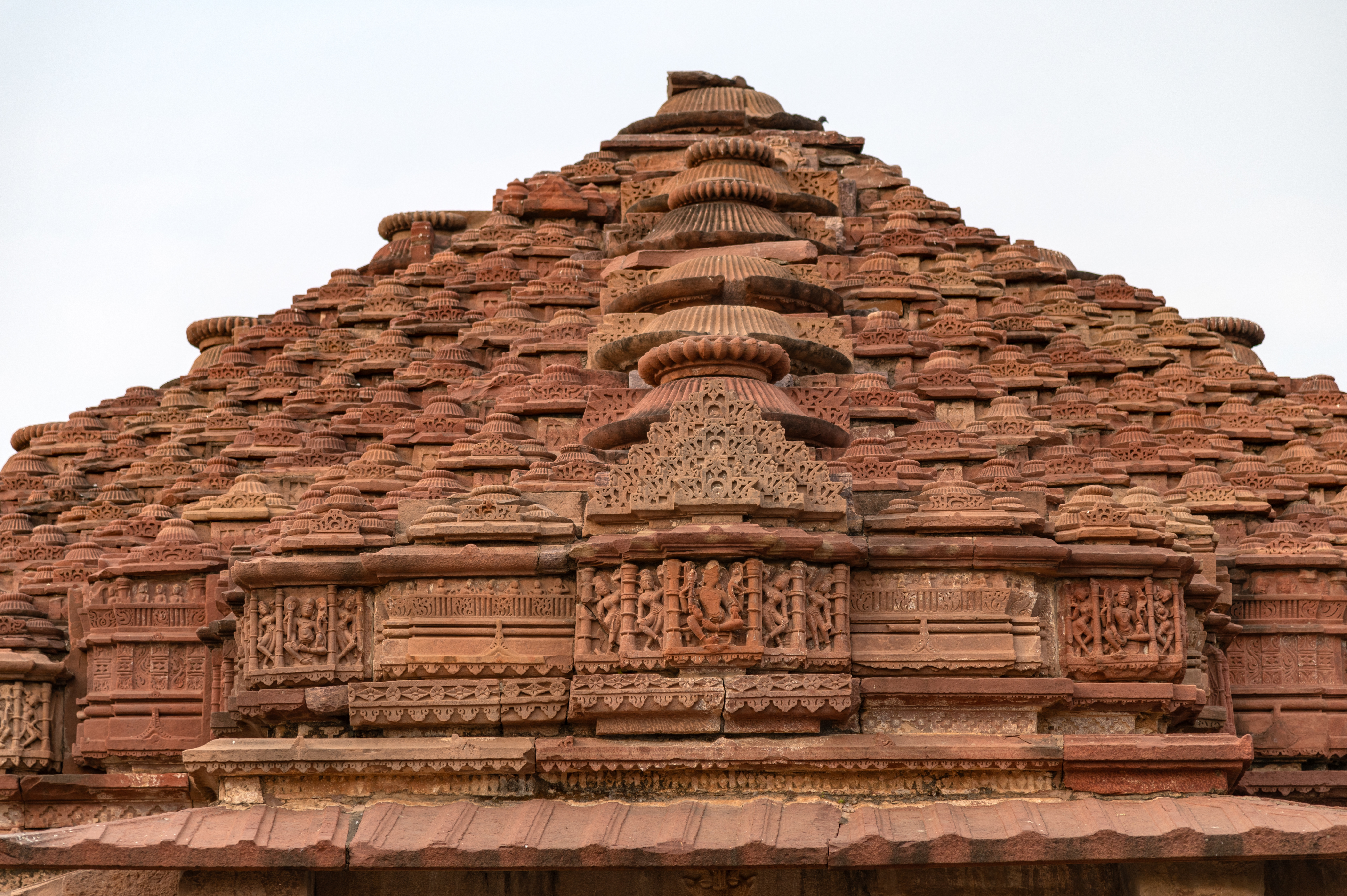 Seen here is the samvarna variety of pyramidal shikhara of the Mahanaleshwar temple. Each of the small aedicules is composed of small discs that descend like a pyramid. Since the aedicules have bell-like finials, the type of shikhara is known as ghanta samvarna.