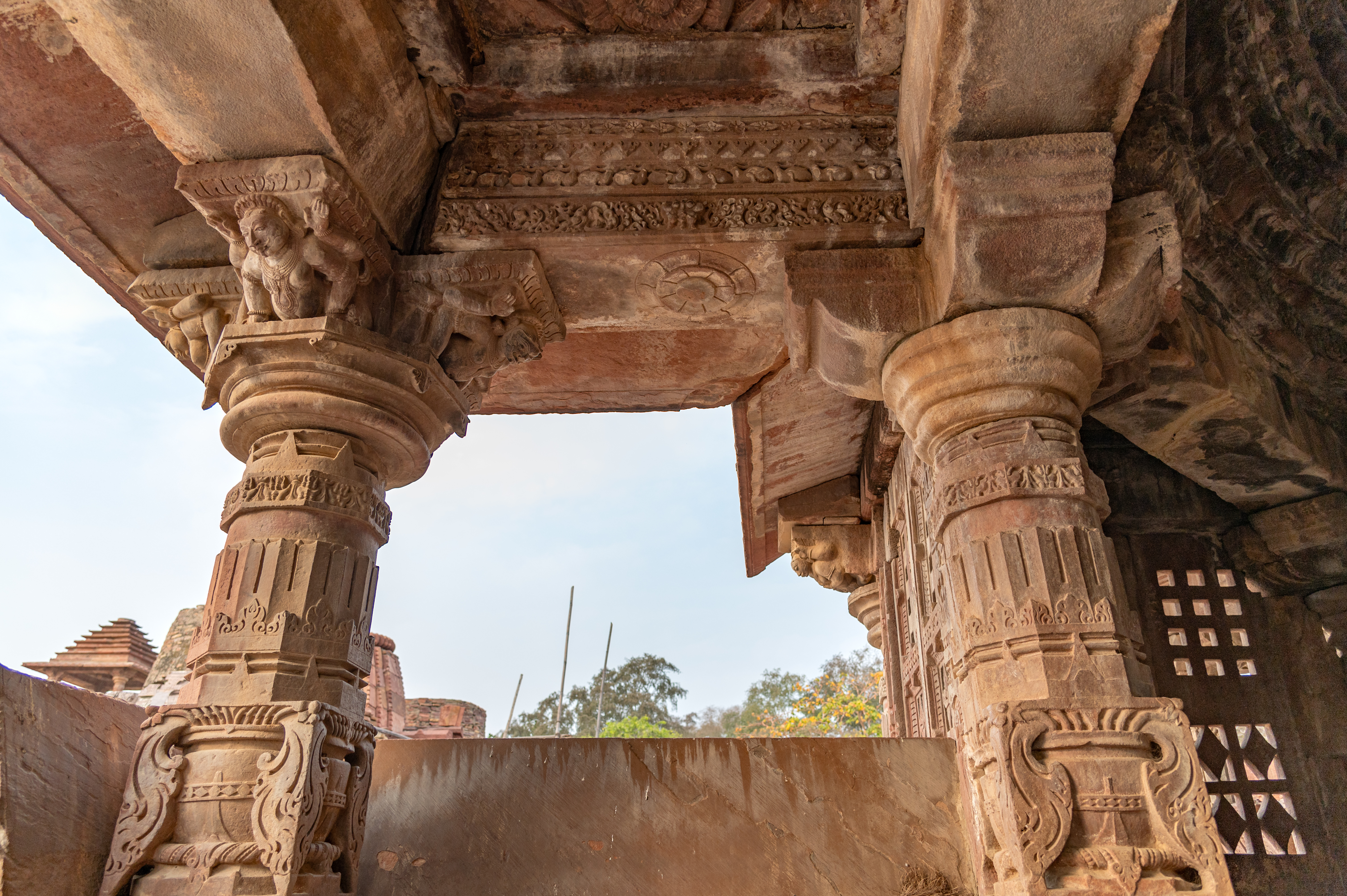This is the closer view of the pillars of the Mahanaleshwar Temple's mukhamandapa (front porch). The four pillars, two on either side of the entrance, support the rectangular ceiling. The pillars of the mukhamandapa are square and of the ghatpallava variety, meaning one block is decorated with vases and foliage motifs.