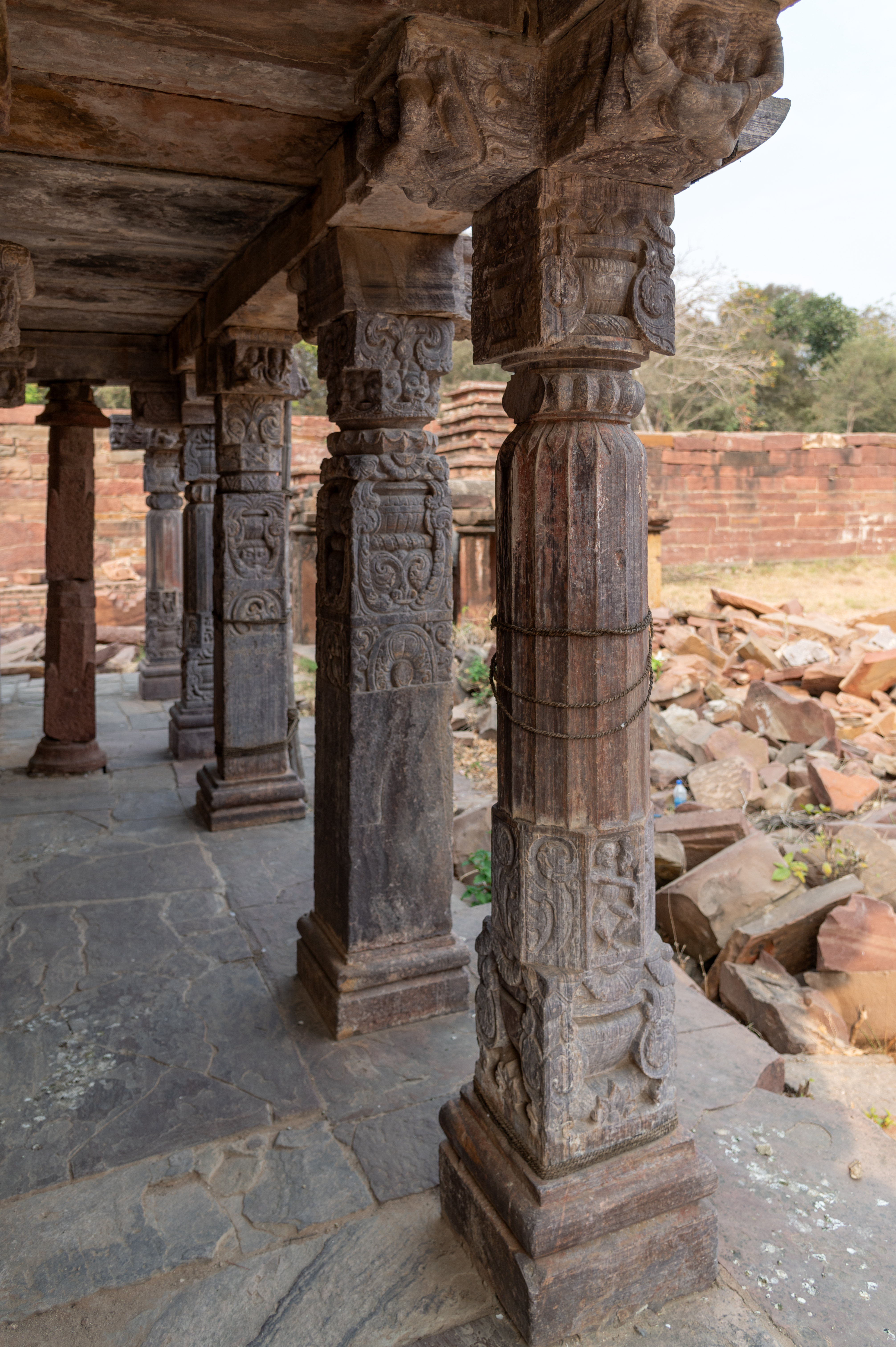 The entrance porch of the Triple-shrine Temple is adorned with pillars. A rectangular porch connects the three shrines, featuring two types of pillars: one with a fluted shaft and the other with a square shaft. The square shaft variety is similar to the reused pillars in the mandapa (pillared hall) of the matha (monastic or residential building) in the Mahanaleshwar temple complex.