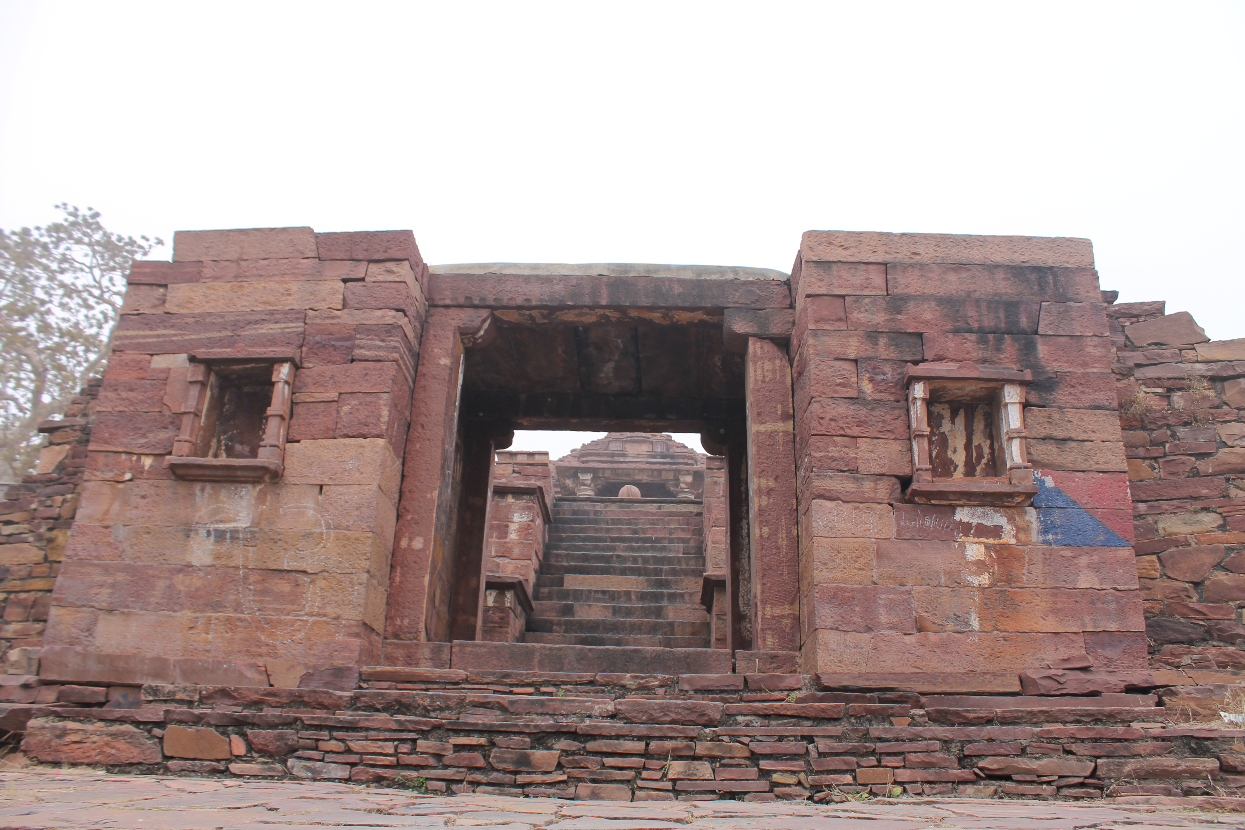 Situated to the west of the Menali stream, the Suhaveshwar temple complex sits slightly apart from the Mahanaleshvar temple complex. An entrance gateway, located to the east of the complex, provides access to the complex. This entrance gateway's superstructure has not survived. Two broad walls flank the main entrance opening. There is minimal ornamentation on this entrance gateway. The front, east-facing walls of the entrance gateway have empty niches.