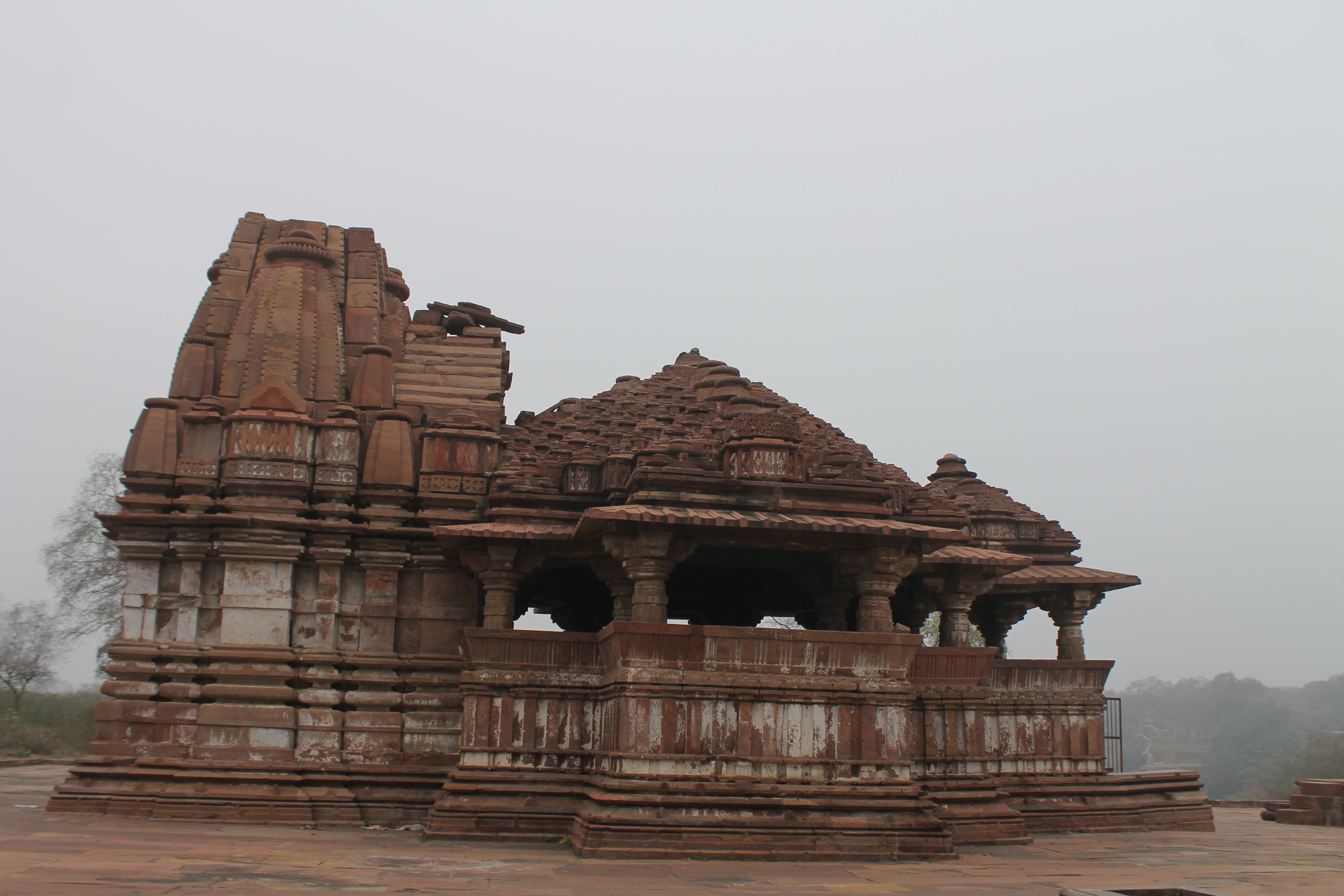 This is the south-facing elevation of the Suhaveshwar Temple's mulaprasada (main shrine). The juncture where the mandapa (pillared hall) meets the main shrine has a plain wall with only one band of ornamentation at the centre. This forms the kapili, which corresponds to the temple's antarala (vestibule or antechamber). The temple's jangha (wall) is flat, divided into two parts by a plain band.