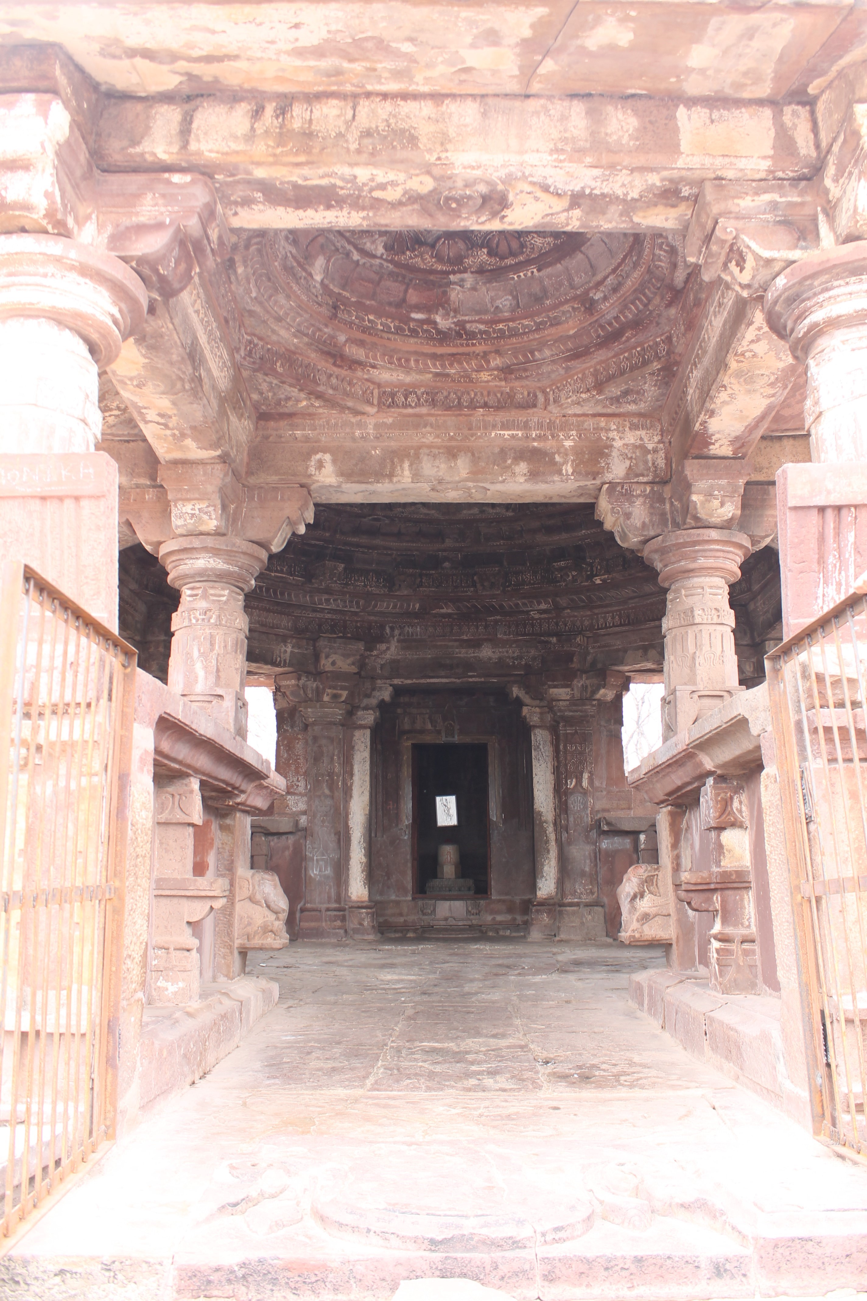 The Suhaveshwar Temple's mandapa (pillared hall) is visible from its mukhamandapa (front porch). The mukhamandapa is composed of two dwarf walls facing each other. The mukhamandapa pillars have cylindrical shafts in the upper half.