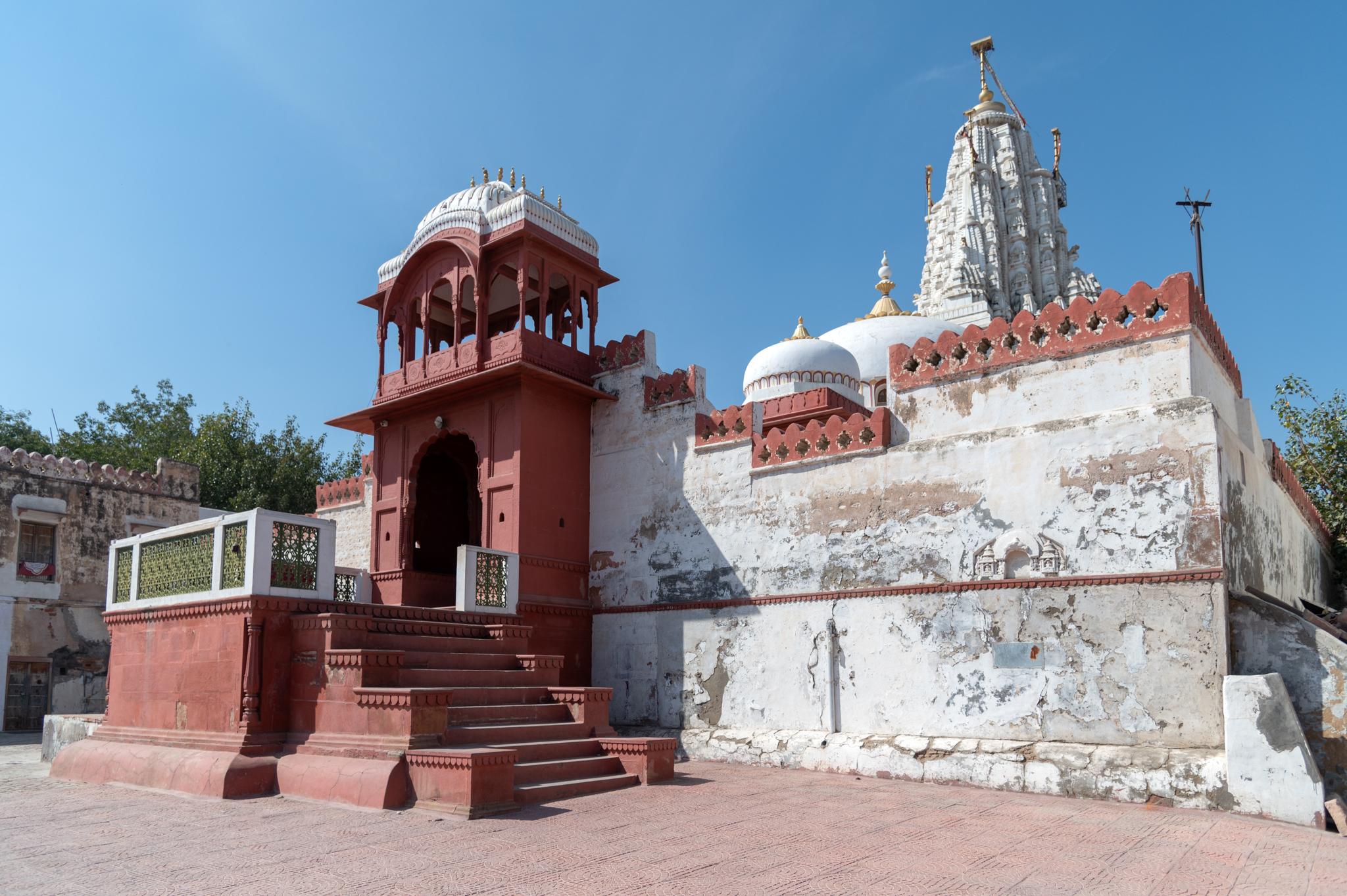 Image 1: The enclosure wall and the main entrance gateway are designed like Nagarkhana. This is the sole entrance to the Bhandasar Temple Complex, which can be reached via a flight of steps. The mulaprasada (main temple) is towering inside the enclosure wall.