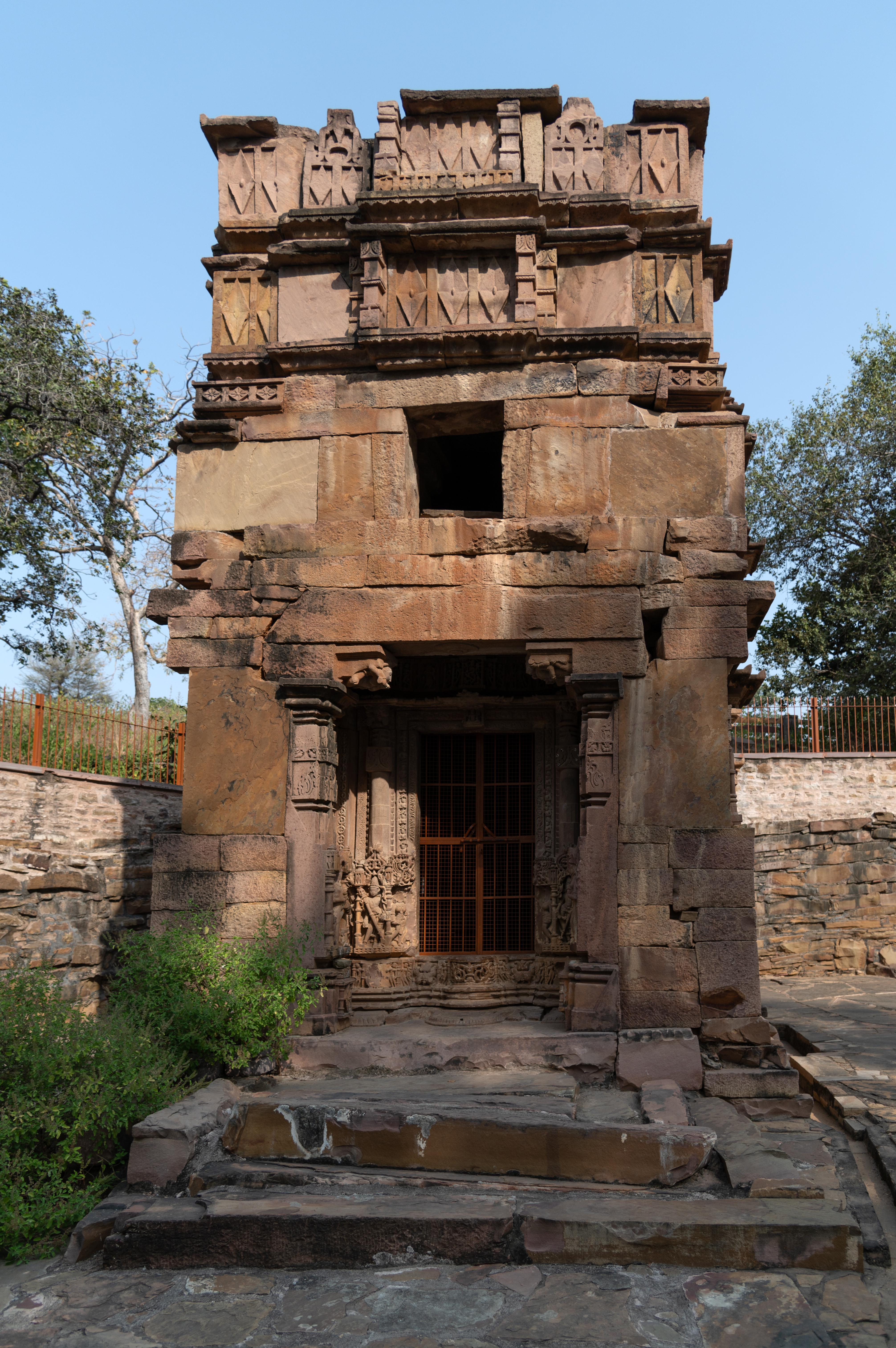 The west-facing Shiva temple now consists of a garbhagriha (sanctum sanctorum) and an antarala (vestibule or antechamber), with the mandapa (pillared hall) having fallen into disrepair. The upper part of the shikhara (superstructure) has been affected by damage. Stylistically, the temple dates back to the 12th century CE.