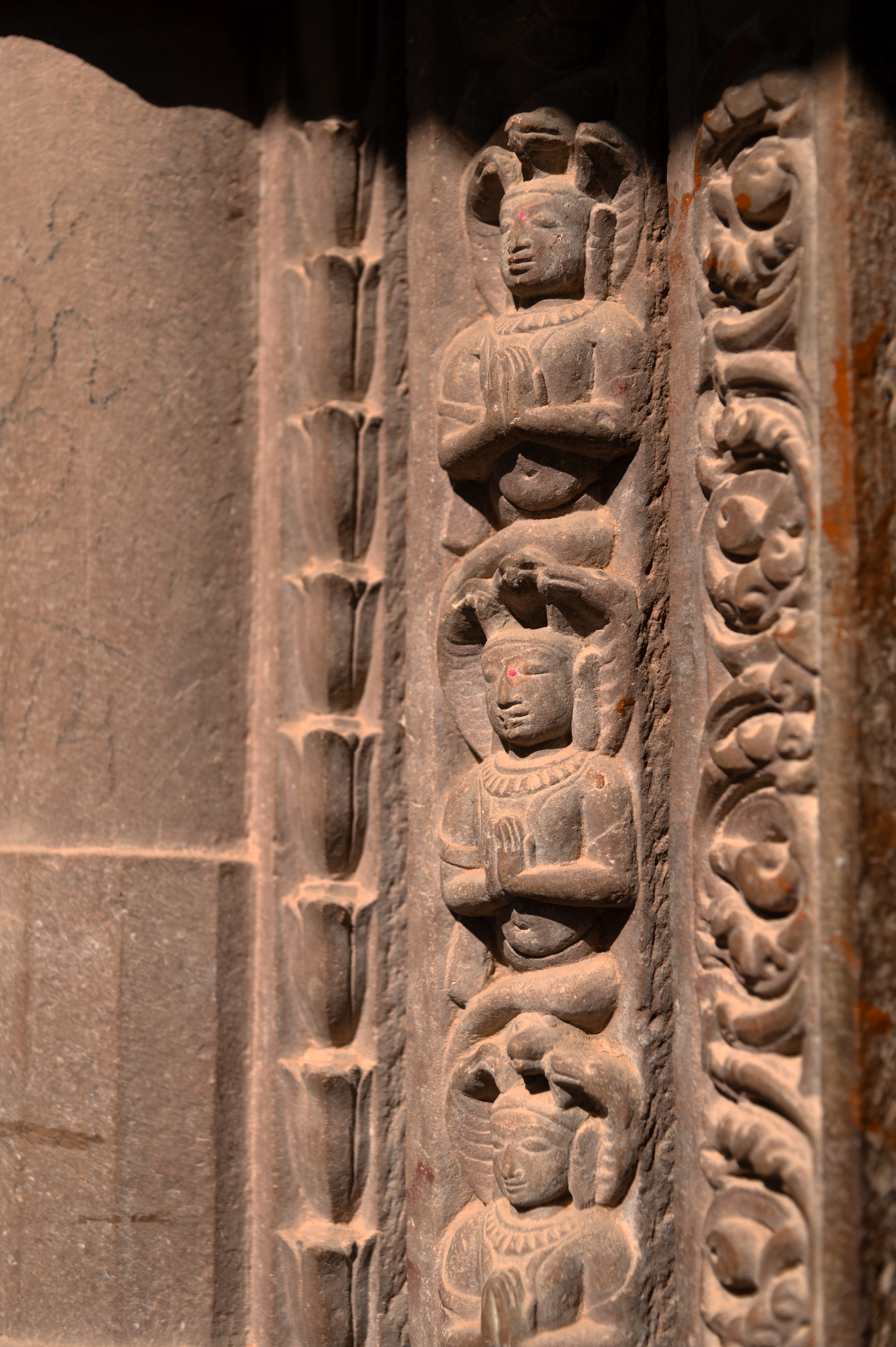  The second shakha (vertical band) of the doorframe of the garbhagriha (sanctum sanctorum) is carved with naga (serpent) figures. These nagas are depicted with human faces and bodies, each adorned with three hoods over their heads, all shown with hands folded in reverence.