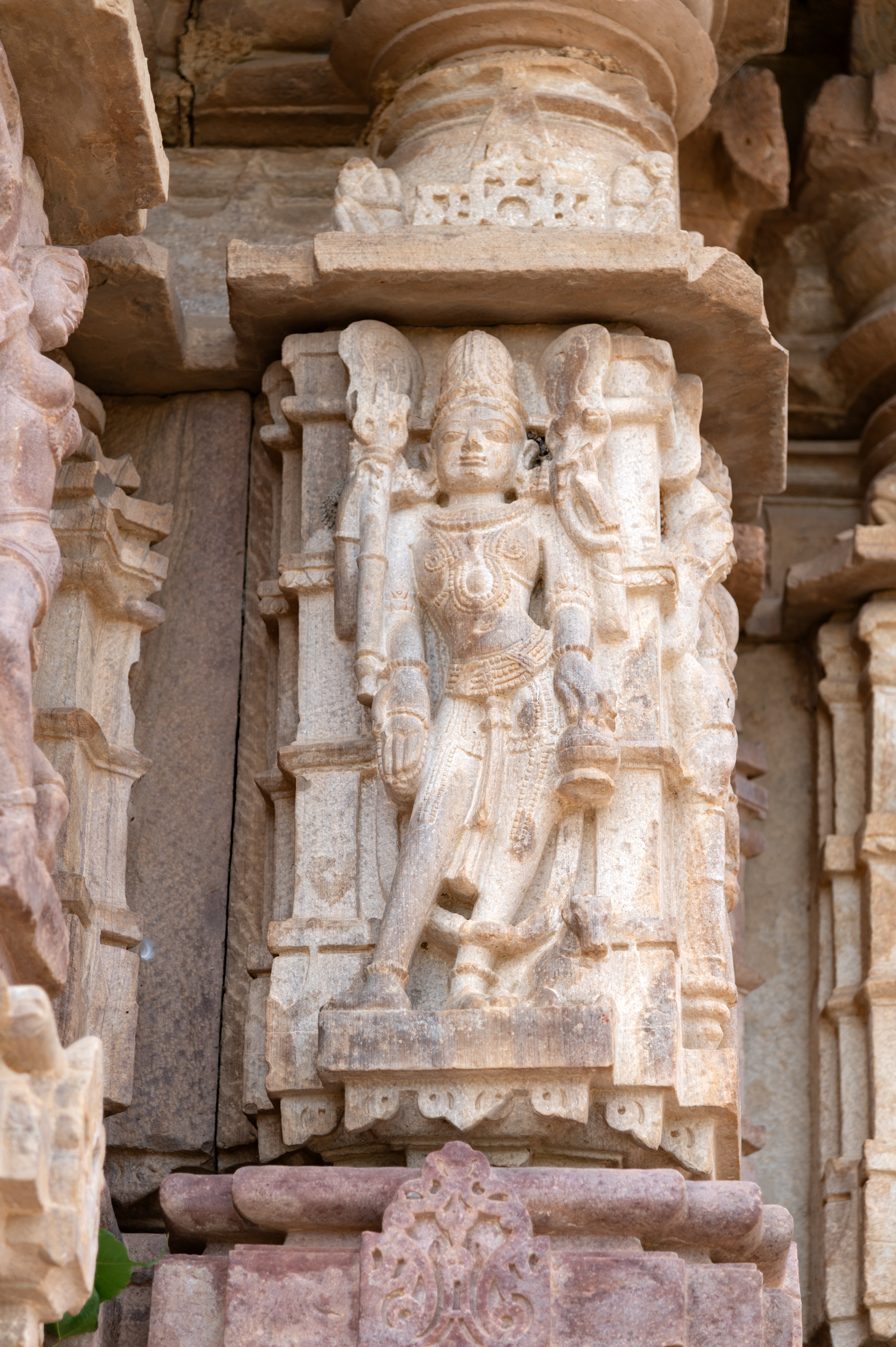 The four-armed Ishana is depicted with a bull, his sacred companion. In his upper right hand, he holds a trishula (trident), while his upper left hand grasps a sarpa (serpent). His lower right hand makes a varada hasta (boon-giving gesture) and holds an akshamala (rosary), while his lower left hand carries a kamandalu (water pot).