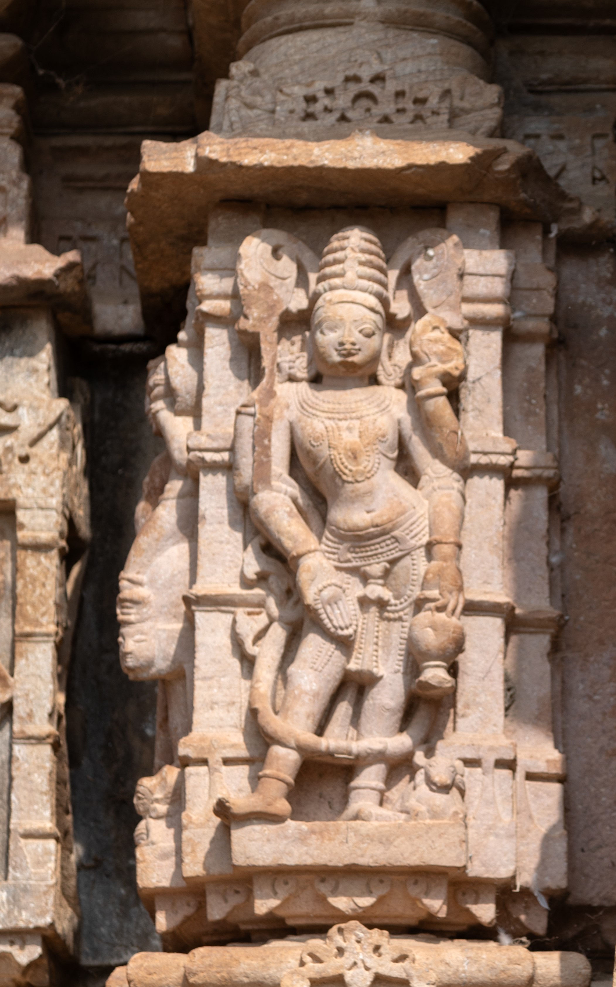 Yama, the guardian of the southern realm, stands with an air of solemnity and grace. Despite the loss of his upper right hand, which once held the danda (rod of justice), his presence remains commanding. In his upper left hand, he holds a rooster. His lower left hand holds a kamandalu (water pot), and his lower right hand holds a rosary and makes a varada hasta (boon-giving gesture). Crowned and adorned with jewels, Yama is accompanied by his mount, the buffalo.