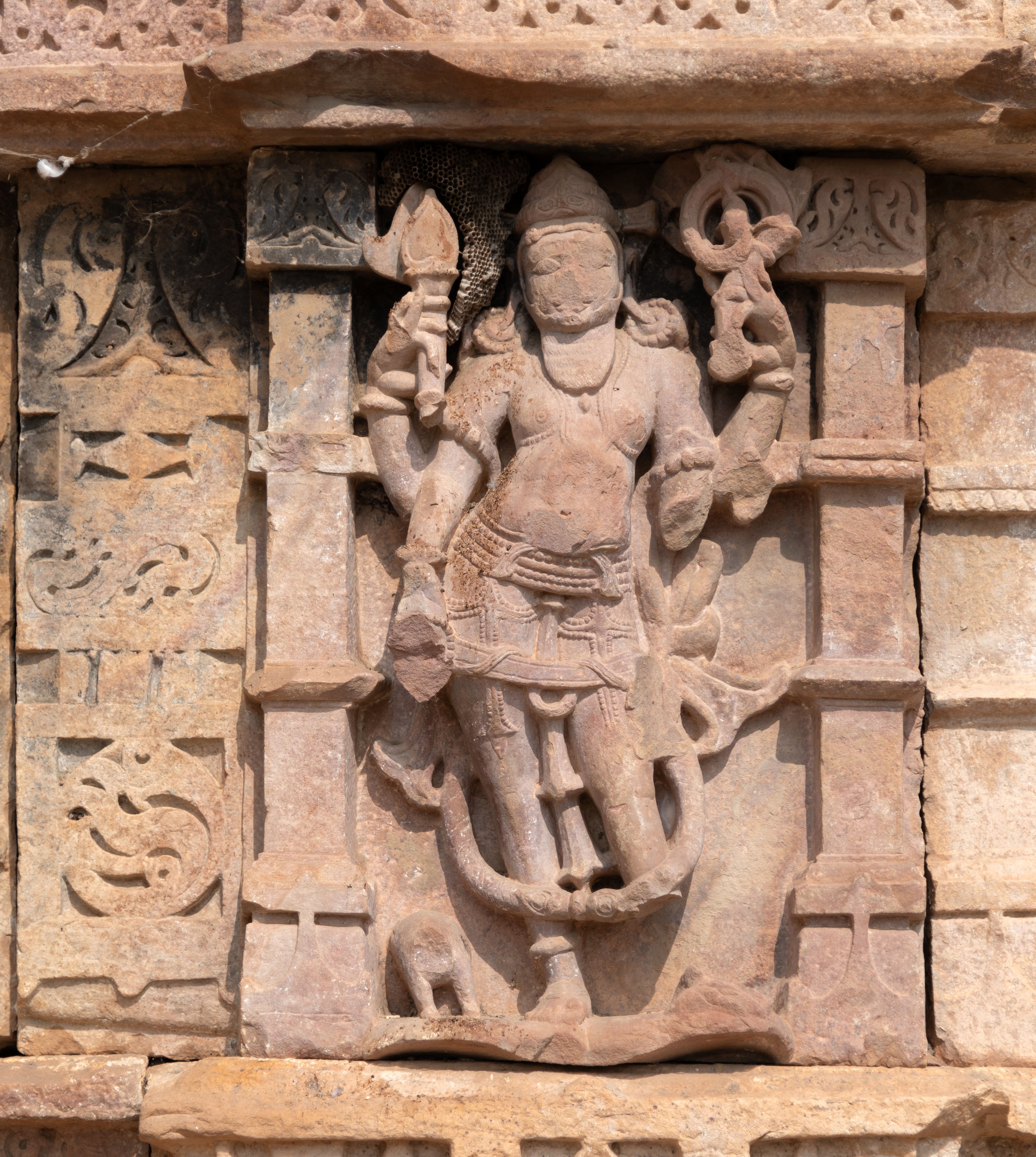 Agni, the guardian of the southeast direction, is depicted holding a pointed spoon and a pushpa (flower) in his upper hands. His lower hands and the face of his vahana (mount) are broken. He wears a jatamukuta (crown of matted hair) and has a beard.