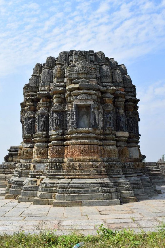 Image 4: A view of the profusely carved east-facing elevation of the temple. The mulaprasada's mouldings, adorned with figural sculptures and geometric patterns, set the temple apart from other structures within the Arthuna temple complex.