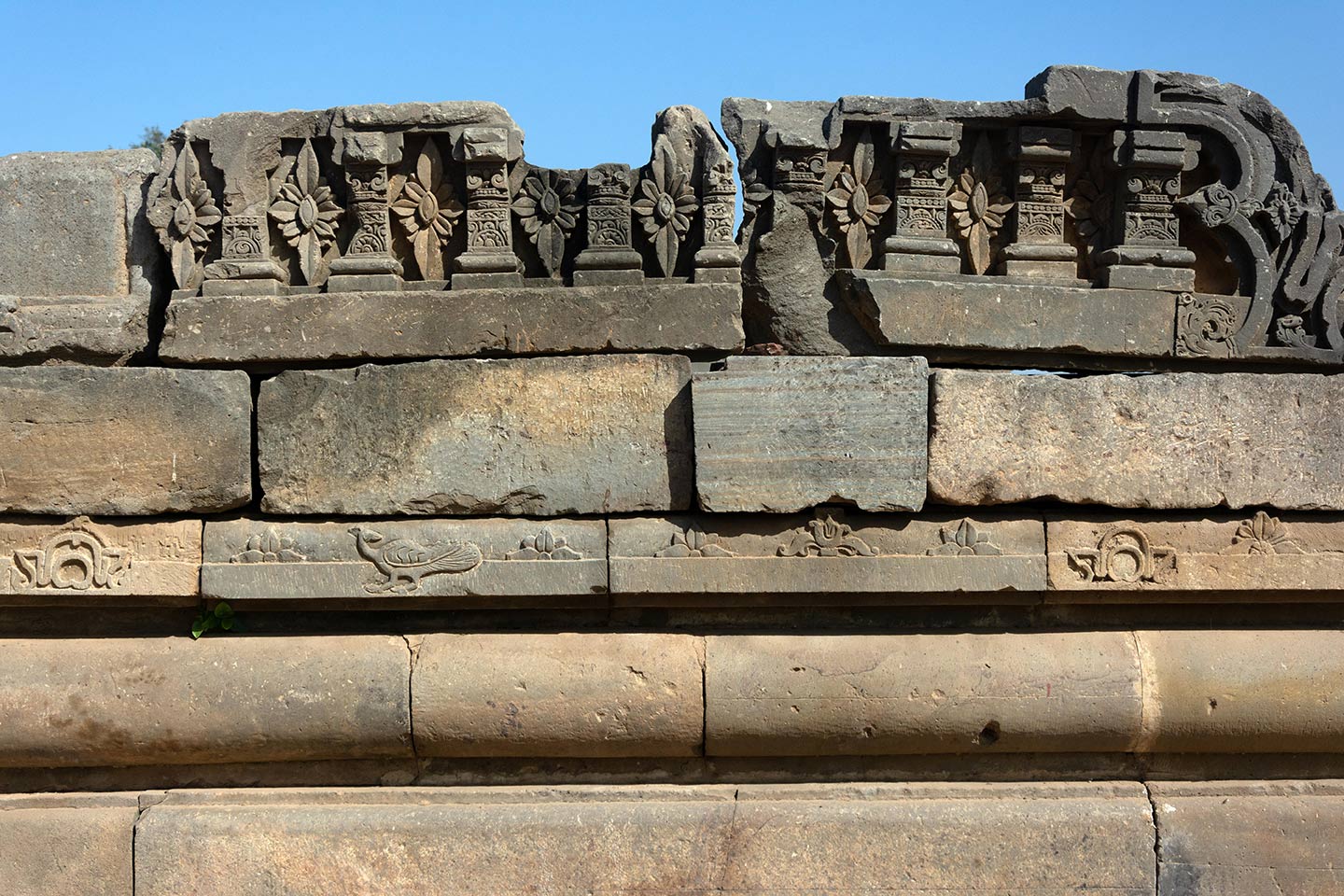 Broken fragments and debris from the original temple assembled on the adhisthana on the southeast side.