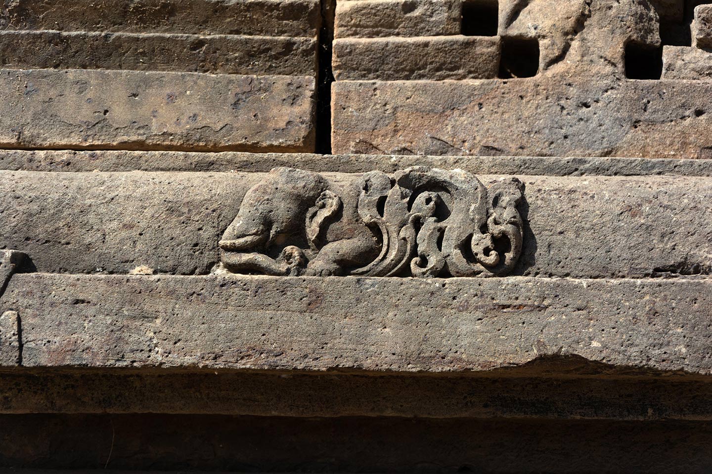 The adhisthana features relief carvings of hybrid creatures such as kinnaras, vyalas, and makara. Here is a carving of a gaja vyala (elephant with wings).