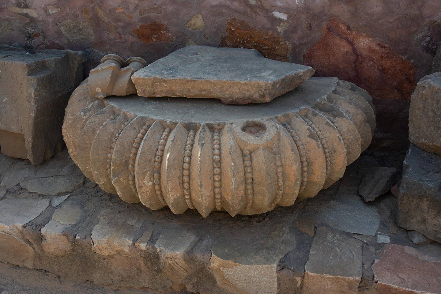 Damaged fragments of amalaka, now kept along the south boundary wall with other broken fragments recovered from the debris of the original temple.