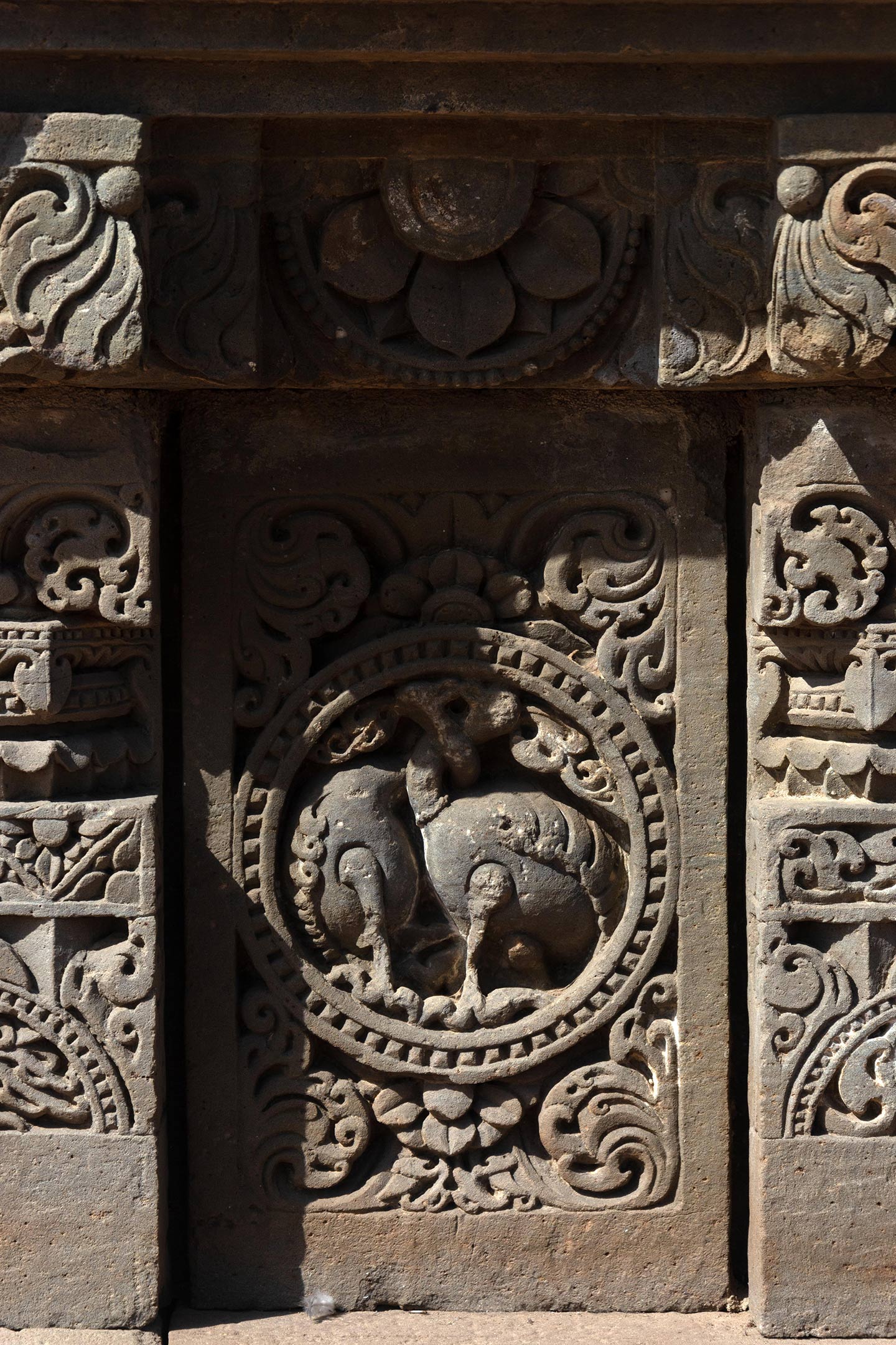 This plaque features two birds, likely hamsas (swans), with their necks entwined. The plaques are separated by squat pillars which have a square base, an octagonal shaft, and a square capital. The pillars are decorated with ardha padma (half lotus) and kalpa lata (creeper) motifs.