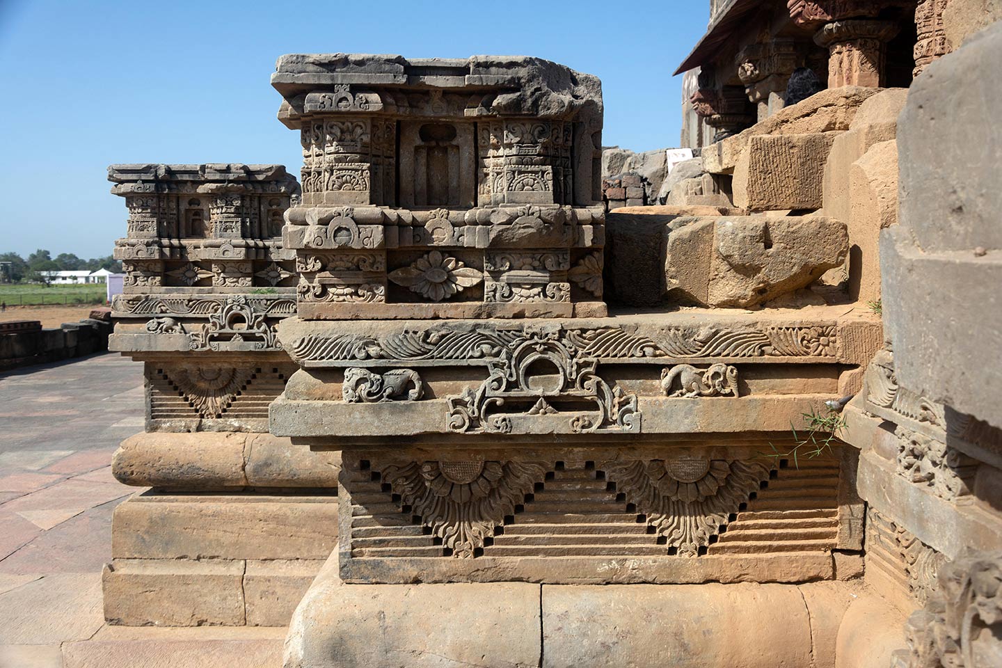 The stones are tightly arranged, richly detailed, and deeply carved, creating contrasting shadows that make the artwork look three-dimensional in sunlight. The carvings depict a variety of flora and fauna, as well as hybrid creatures like kinnaras, vyalas, and makara.