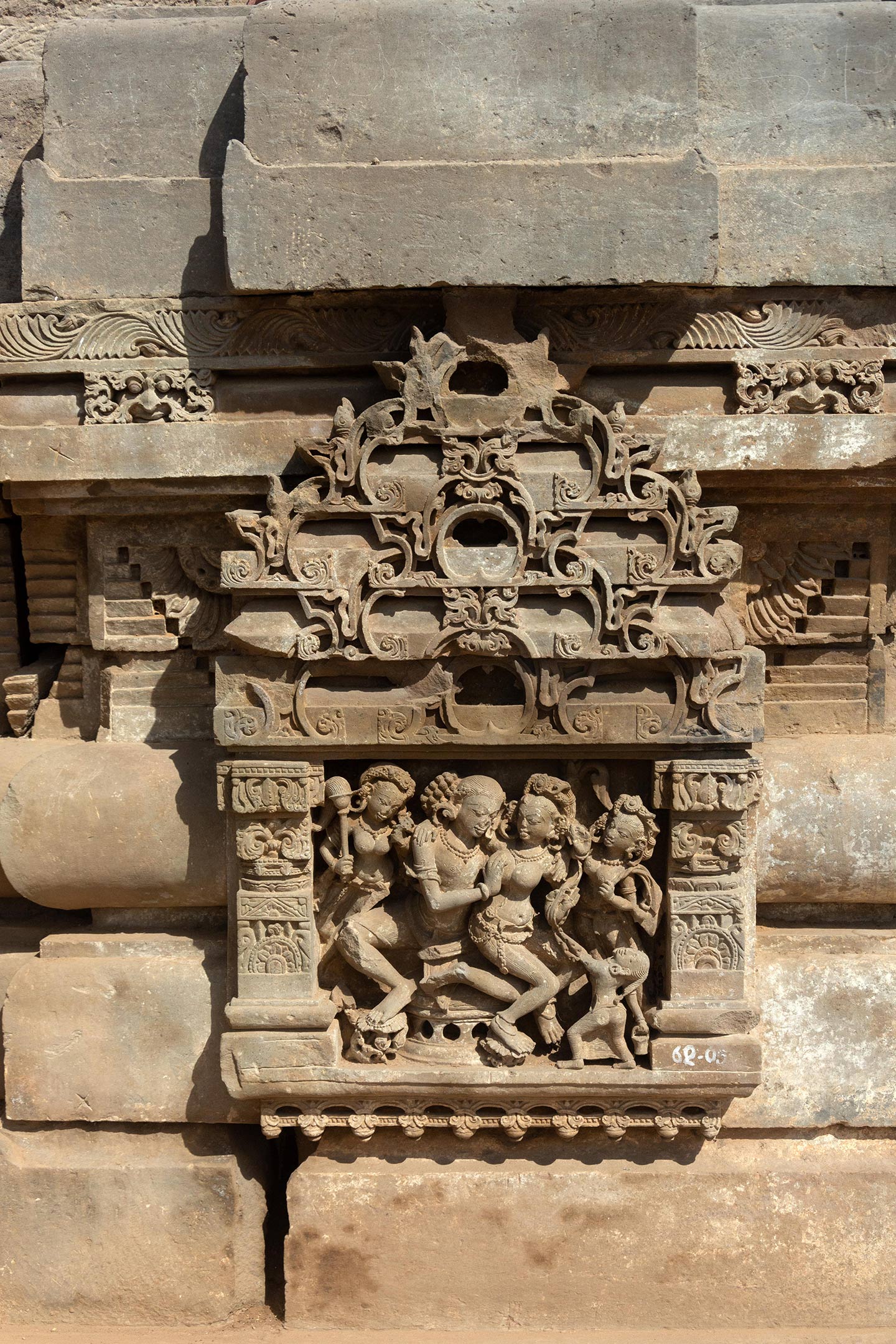 Couples invoking shringara rasa (associated with romance, love, and attractiveness between lovers) are framed in panels with pillars and tiered shikhara with gavaksha (horseshoe) motifs. Unlike in other parts of the temple, the faces are not damaged and they wear heavy jewellery, elaborate headgear, and garments, indicating they belong to royalty or a high social class.
