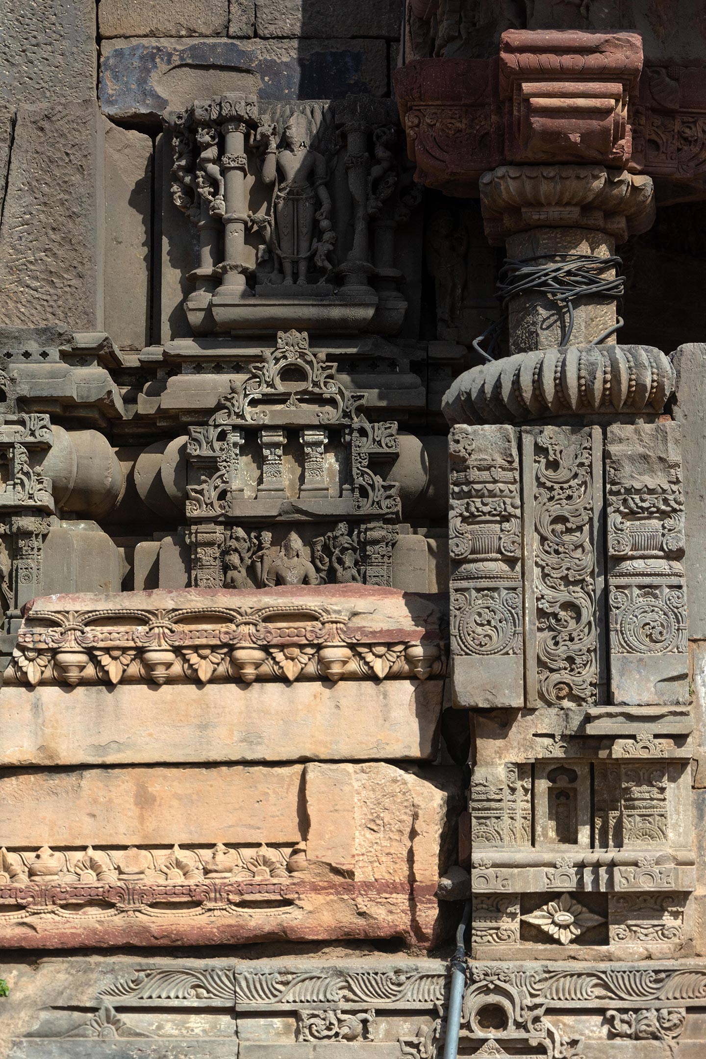 Different coloured stones are assembled here, some in pink sandstone and the rest in grey sandstone. The pink sandstone has floral designs with Stupa (dome-shaped memorials, made on the holy relics of the Buddha) motifs. The grey sandstone has the padma (lotus), the purna ghata (overflowing pot of prosperity), and the kalpa lata (creeper) motifs.