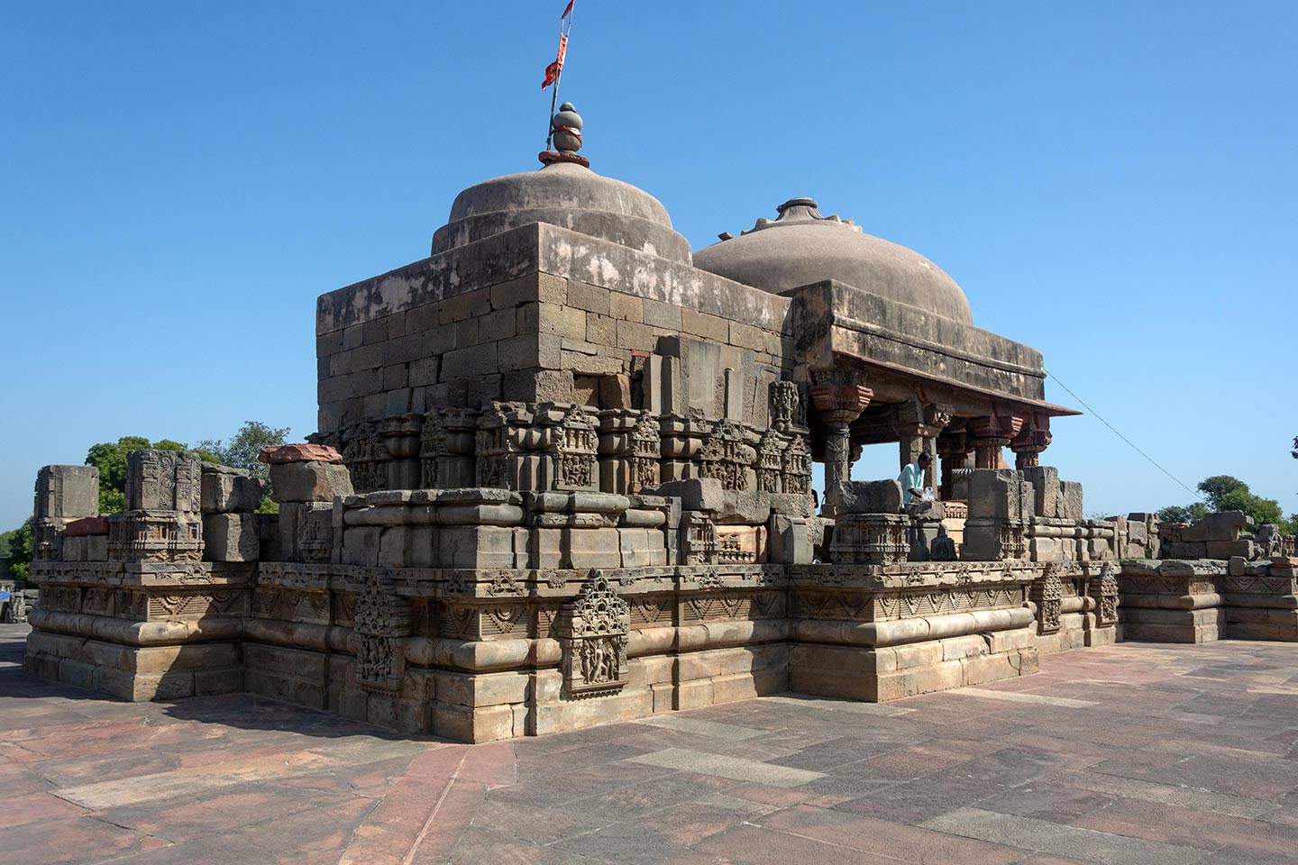 The jagati has two projected niches on the south and north sides and a single projected niche on the west side. The dome pedestal and the domes on top of the mandapa (pillared hall) and the garbhagriha (sanctum) are made of concrete instead of stone, which is used in the rest of the temple structure. The open space surrounding the jagati is the pradakshina path (circumambulation path) on the adhisthana.